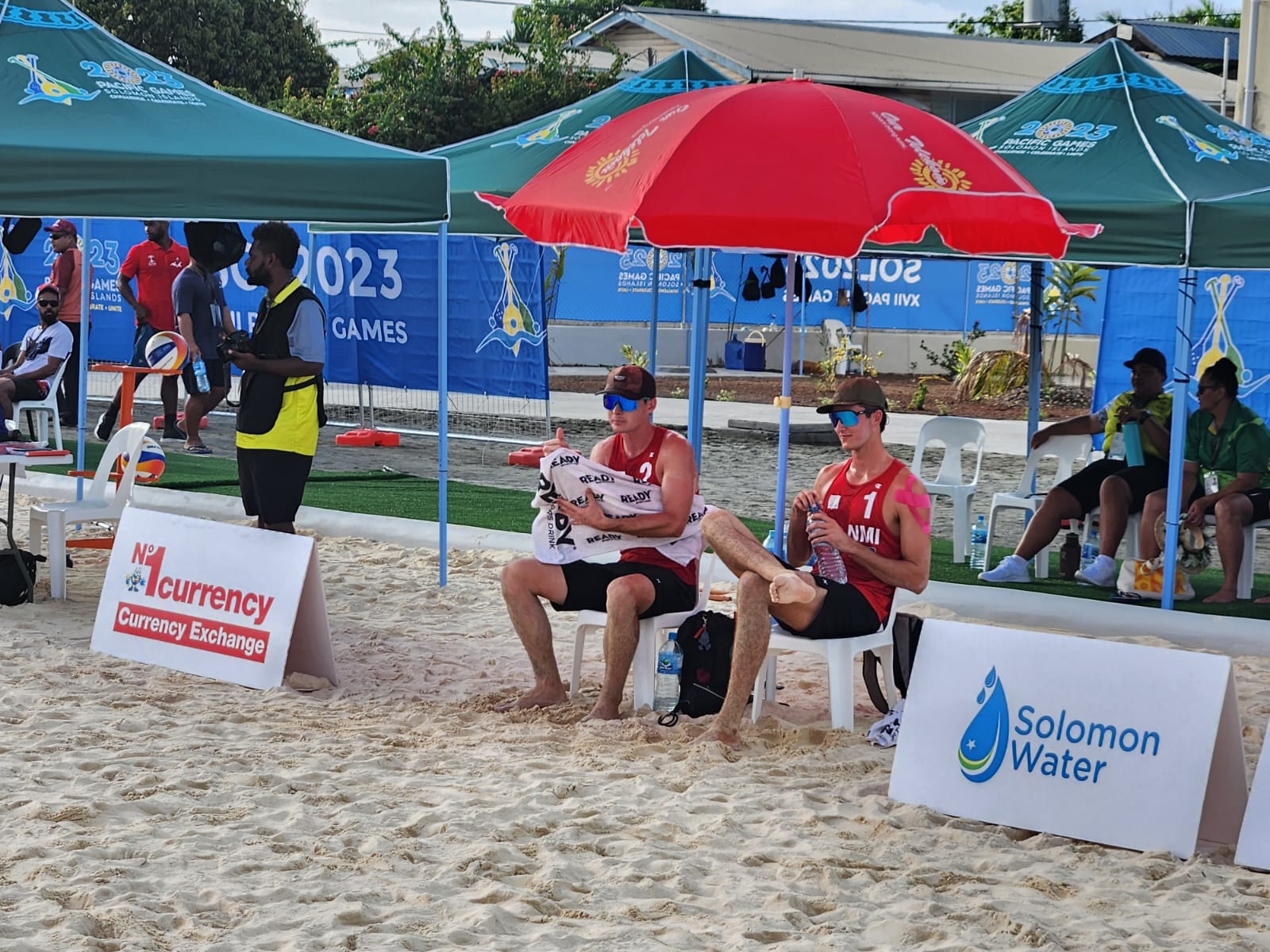 Andrew Johnson, left, and Logan Mister takes a breather after beating Palau in the opening set of their beach volleyball match in the 2023 Pacific Games Tuesday in Honiara, the Solomon Islands.