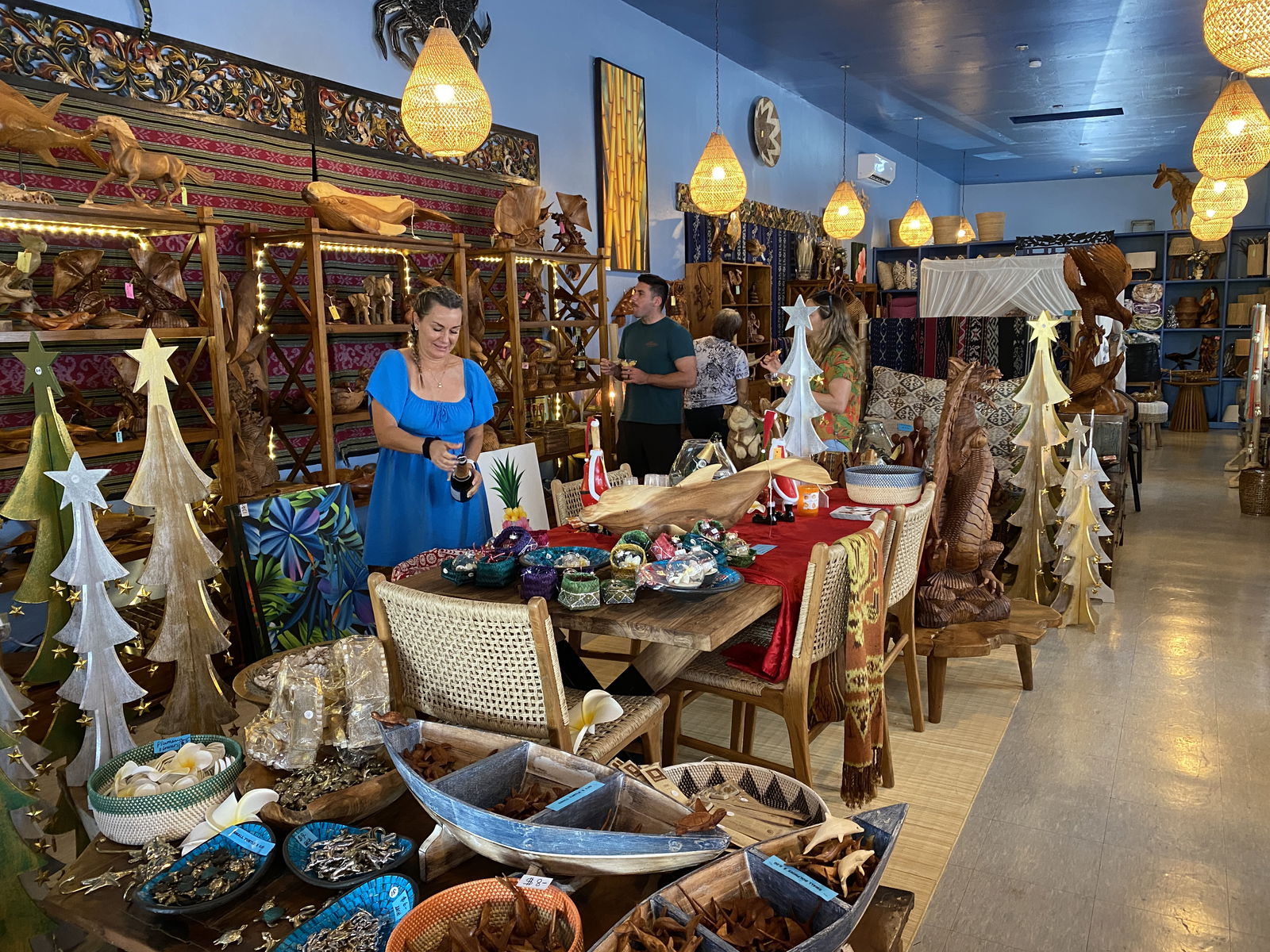 Sandy Weaver pops open a bottle of champaign during the soft opening of Monika's Treasures.