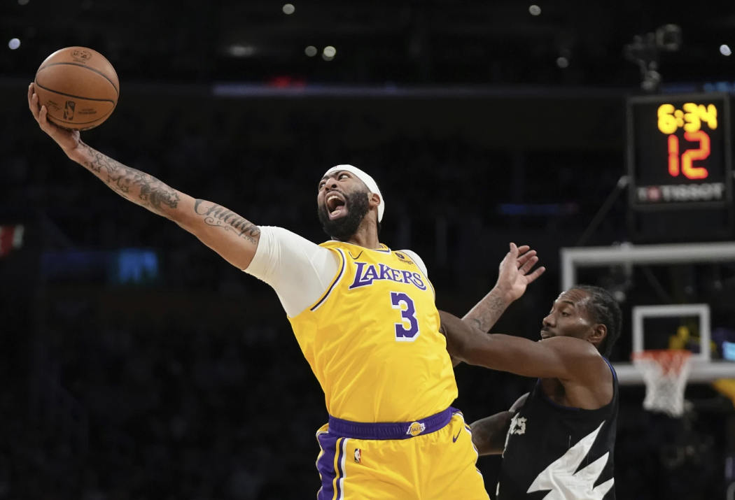 Los Angeles Lakers forward Anthony Davis, left, reaches for a loose ball after blocking a shot by Los Angeles Clippers forward Kawhi Leonard, right, during the first half of an NBA game Wednesday, Nov. 1, 2023 in Los Angeles.