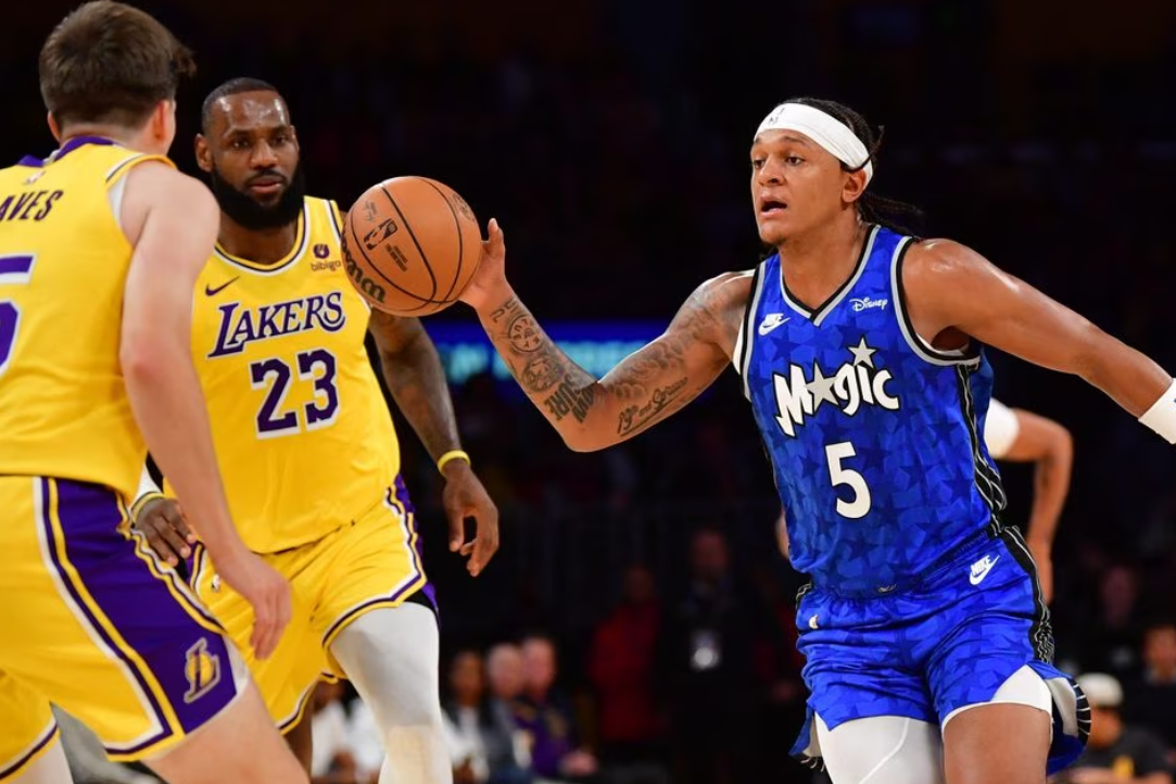 Orlando Magic forward Paolo Banchero (5) moves to the basket against Los Angeles Lakers forward LeBron James (23) and guard Austin Reaves (15) during the first half at Crypto.com Arena in Los Angeles, California, Oct. 30, 2023.