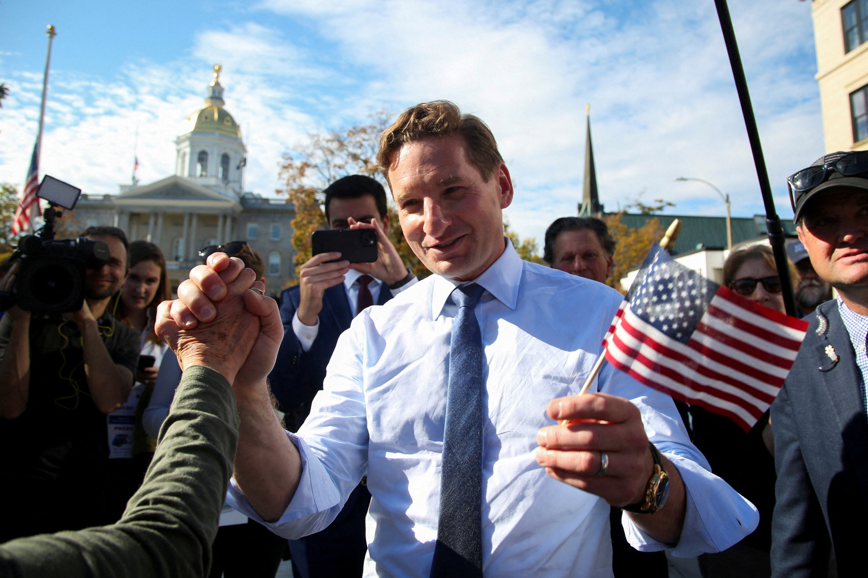 Democratic presidential candidate U.S. Representative Dean Phillips holds hands with a supporter after filing the paperwork to put his name on the ballot for the state’s primary election outside the statehouse in Concord, New Hampshire, U.S., October 27, 2023. 