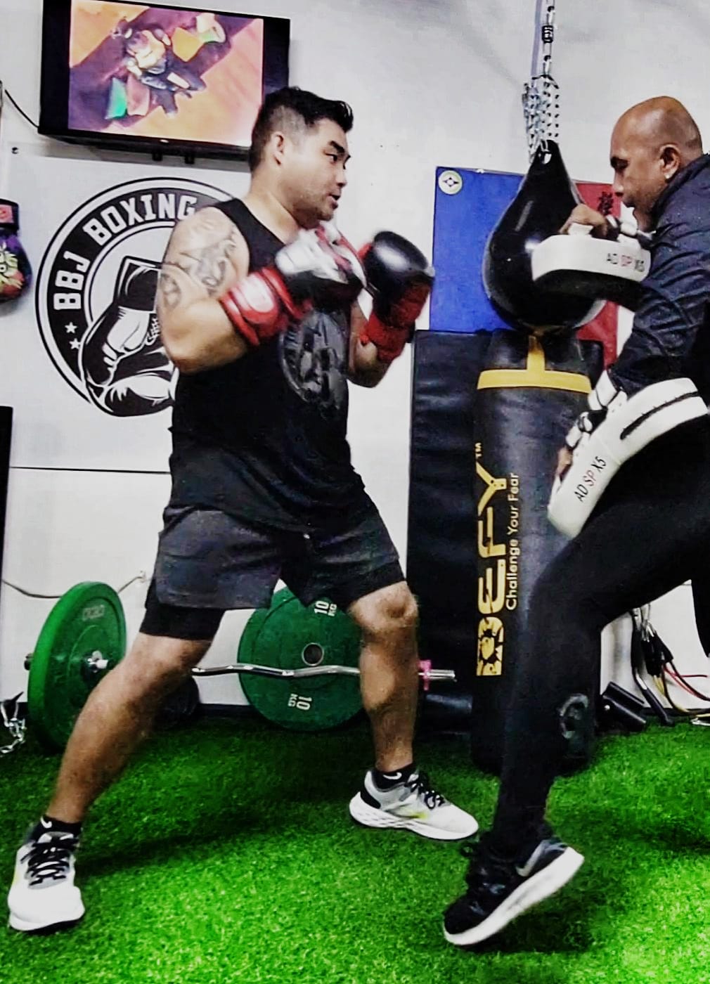 Carldrine Santos, left, performs a boxing exercise with Jerry Diaz at BBJ Athletics.