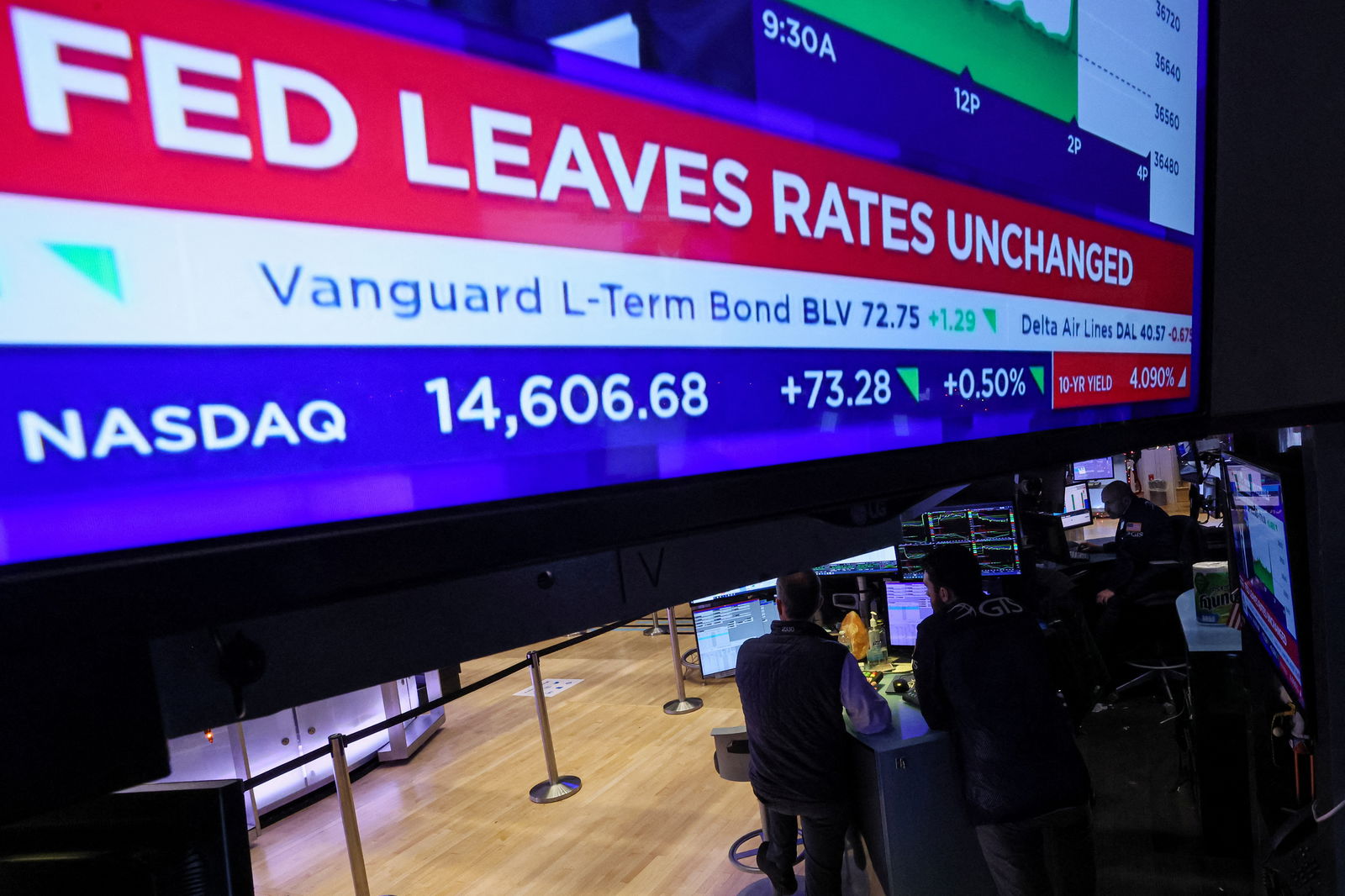 Traders react as a screen displays the Fed rate announcement on the floor of the New York Stock Exchange (NYSE) in New York City, U.S., December 13, 2023. 