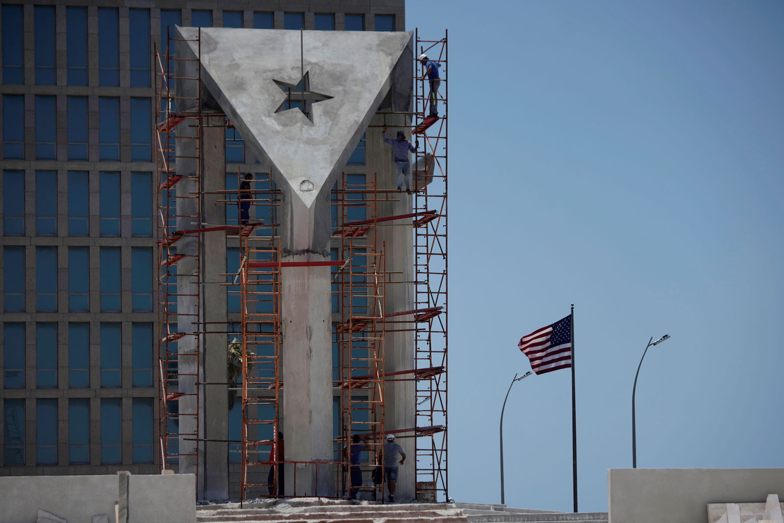 Men work in a monument in front of the U.S. Embassy in Havana, Cuba, May 25, 2021. 