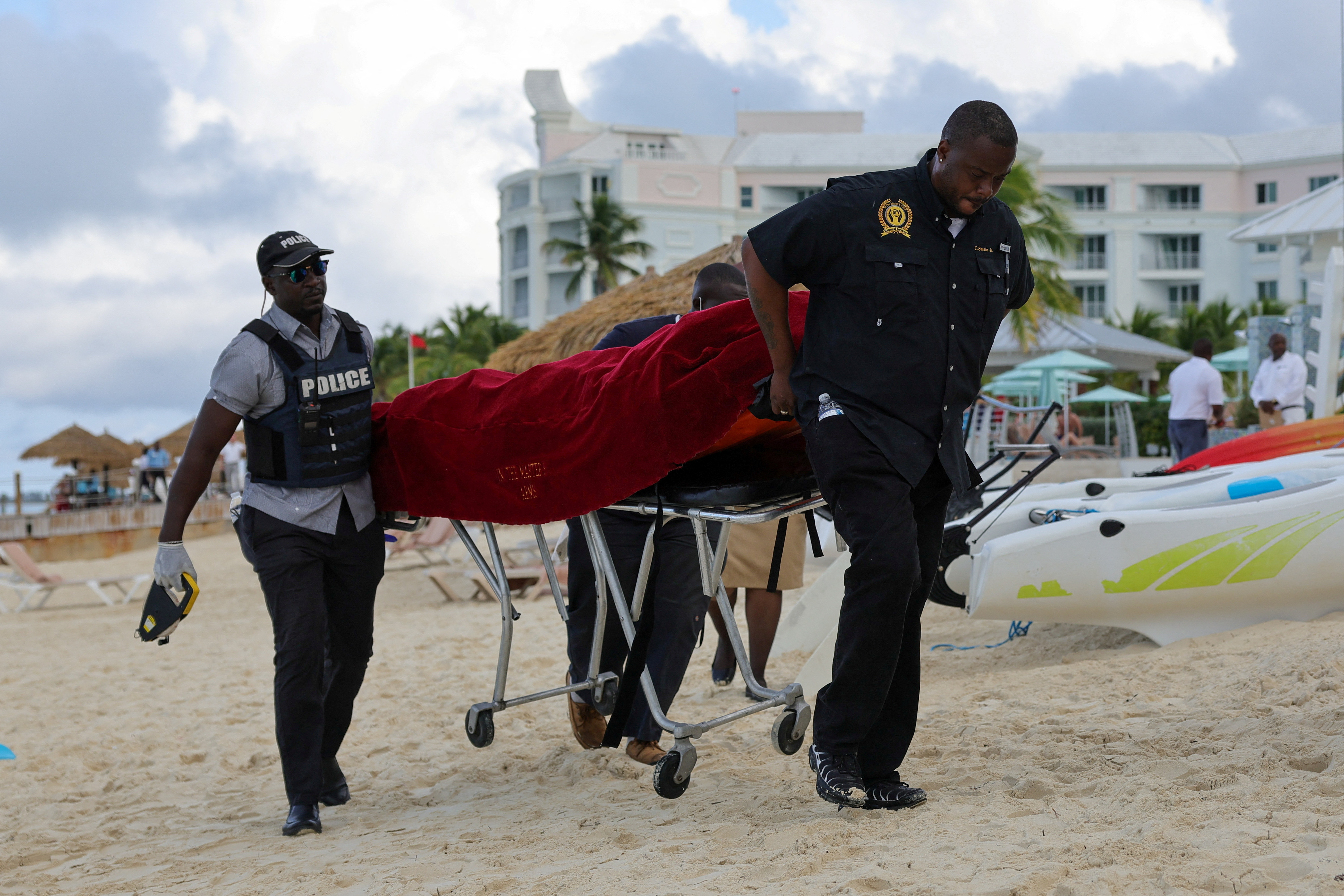 Mortuary services personnel transport the body of a female tourist after what police described as a fatal shark attack in waters near Sandals Royal Bahamian resort, in Nassau, Bahamas December 4, 2023. 