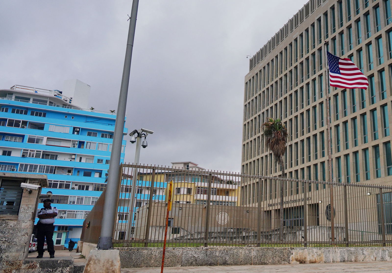 The U.S. flag flies next to a security officer guarding the U.S. embassy in Havana, Cuba, December 12, 2023. 