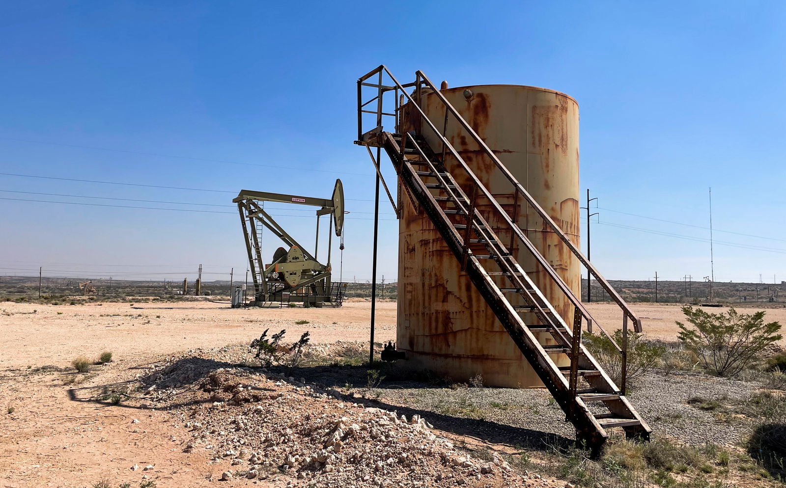 An oil tank and an oil pumpjack are pictured in the Permian basin, Loco Hills regions, New Mexico, U.S., April 6, 2023. 