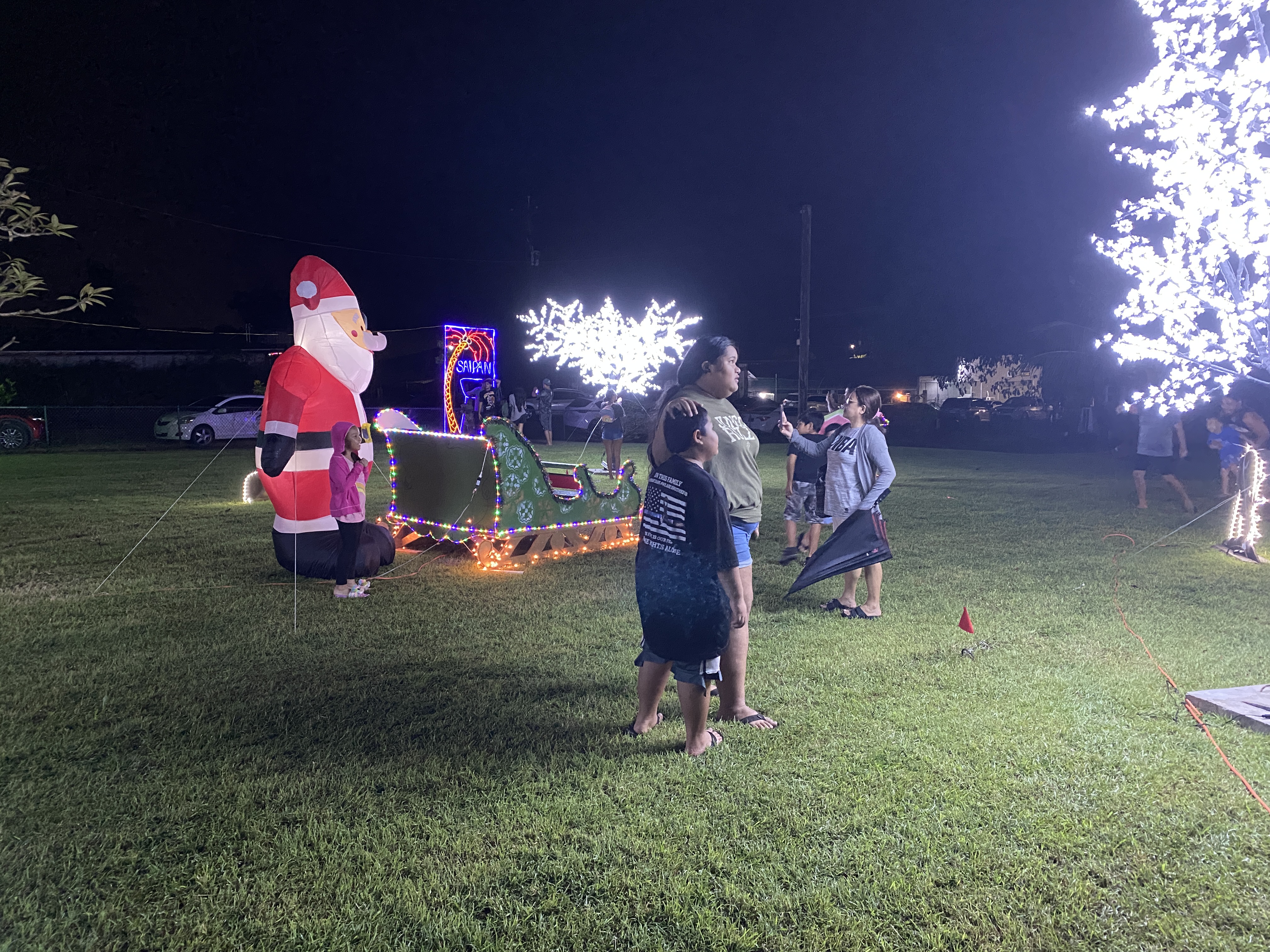 Community members take photos at some of the backdrops set up at Sugar King Park.
