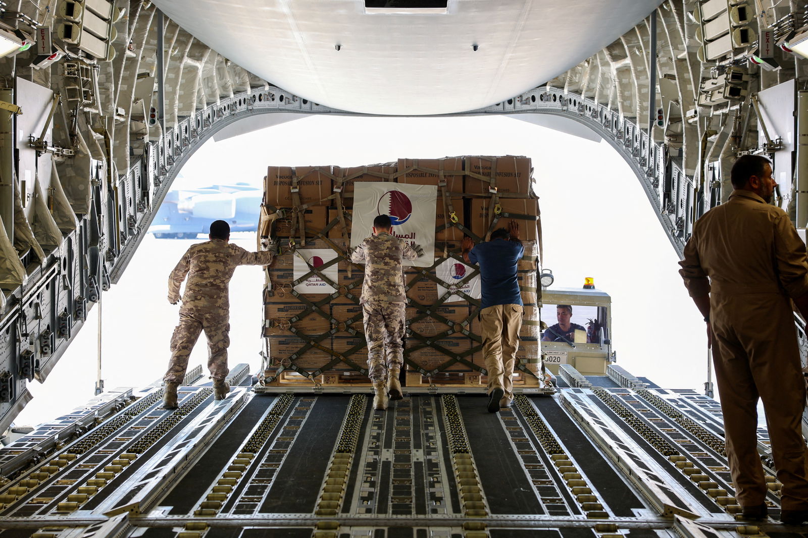 Qatari Amiri Air Force crew load food and medical aid to their cargo plane from the Qatar Fund for Development headed to Egypt for Gaza, at Al Udeid Air Base, Doha, Qatar, October 16, 2023. Q