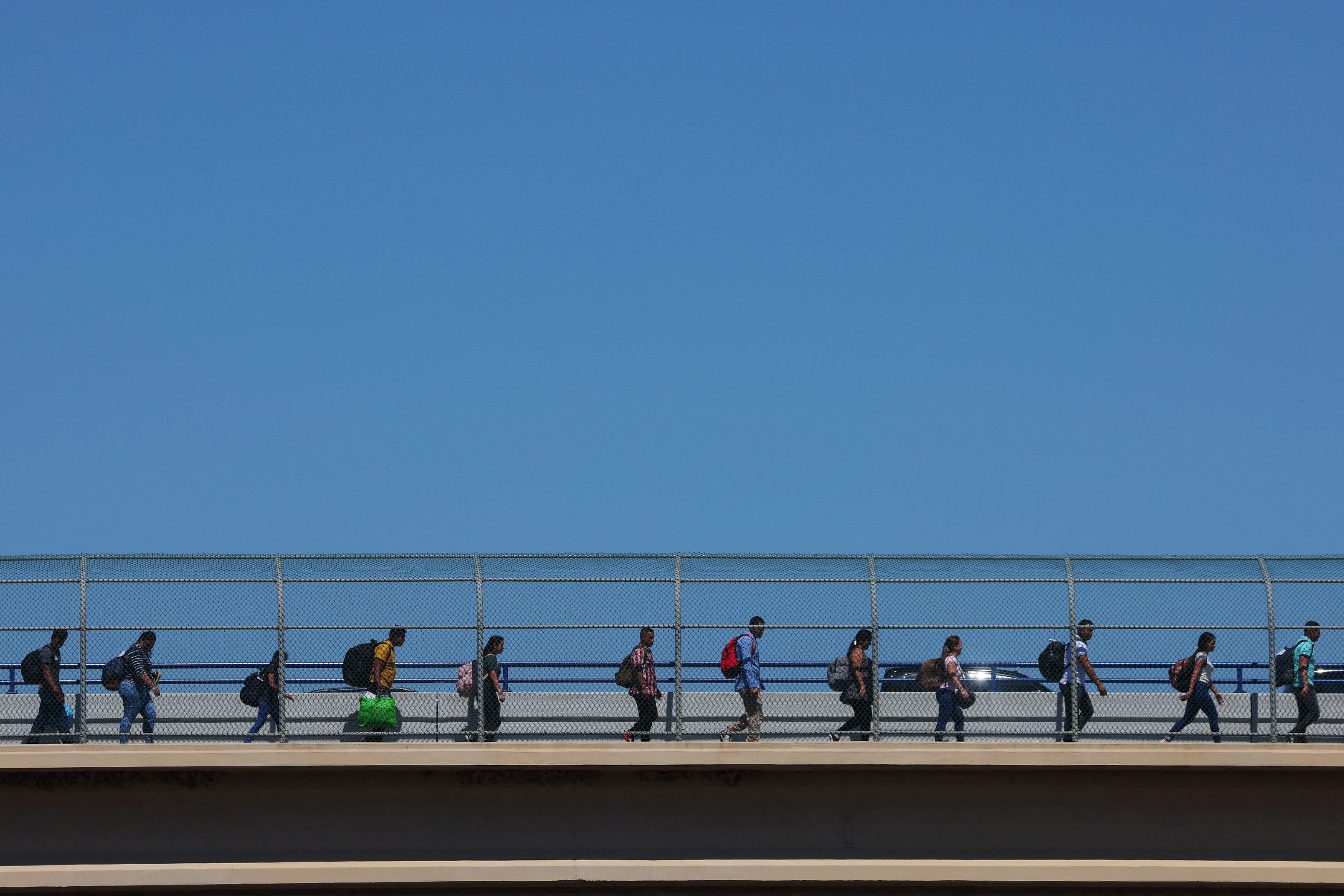 Migrants cross the Eagle Pass International Bridge from Mexico to the U.S., a legal point of entry above a point where many migrants wade across the Rio Grande, for their scheduled appointments with immigration authorities, in Eagle Pass, Texas, U.S., September 28, 2023. 
