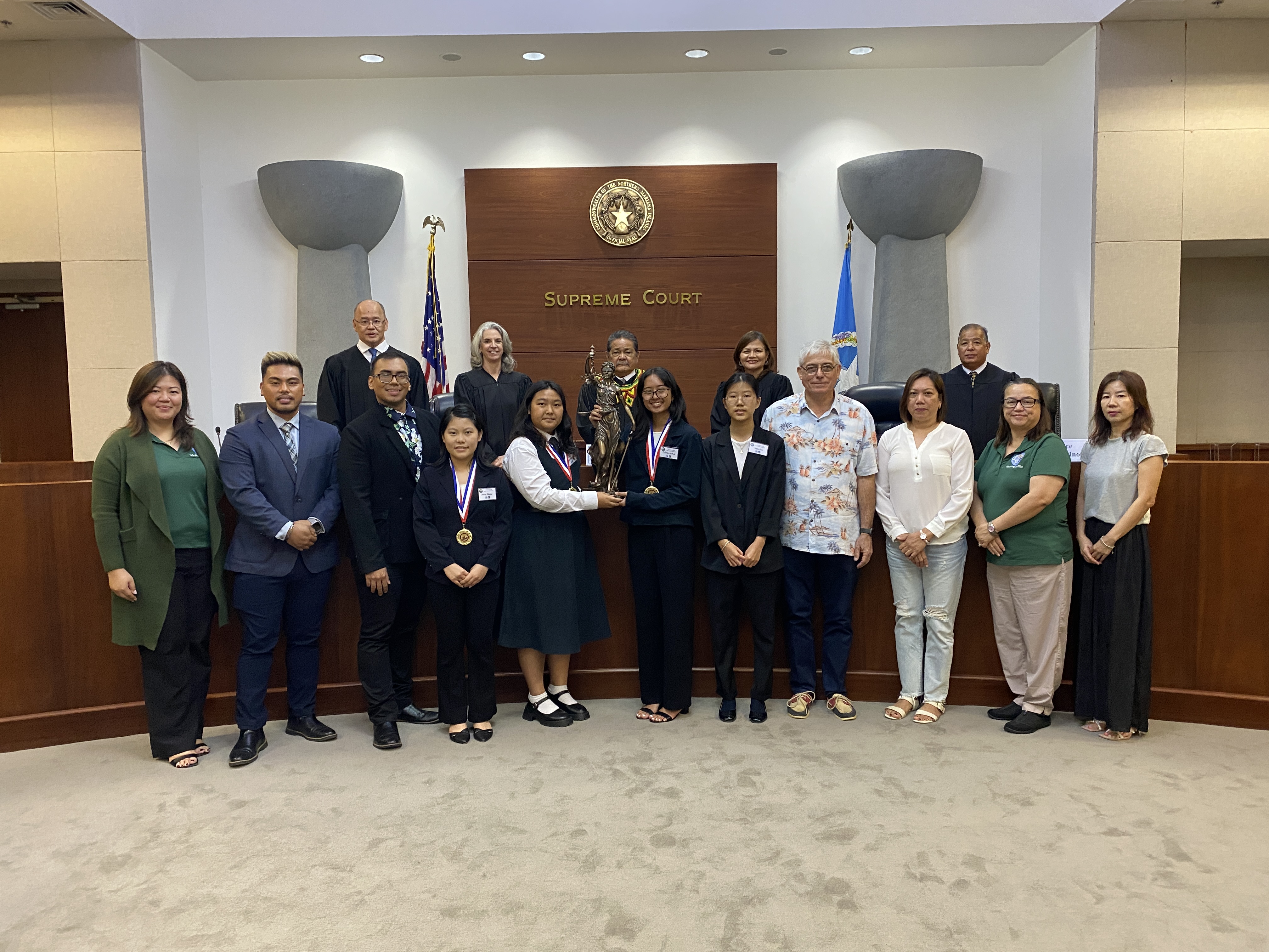 Marianas High School students Jenny Zhang, Julia Taitano, Princes Habal and Yejin Son pose with judicial officials, CNMI judiciary and Public School System staff after the completion of the 2023 High School Moot Court Competition finals on Thursday at Guma Hustisia.