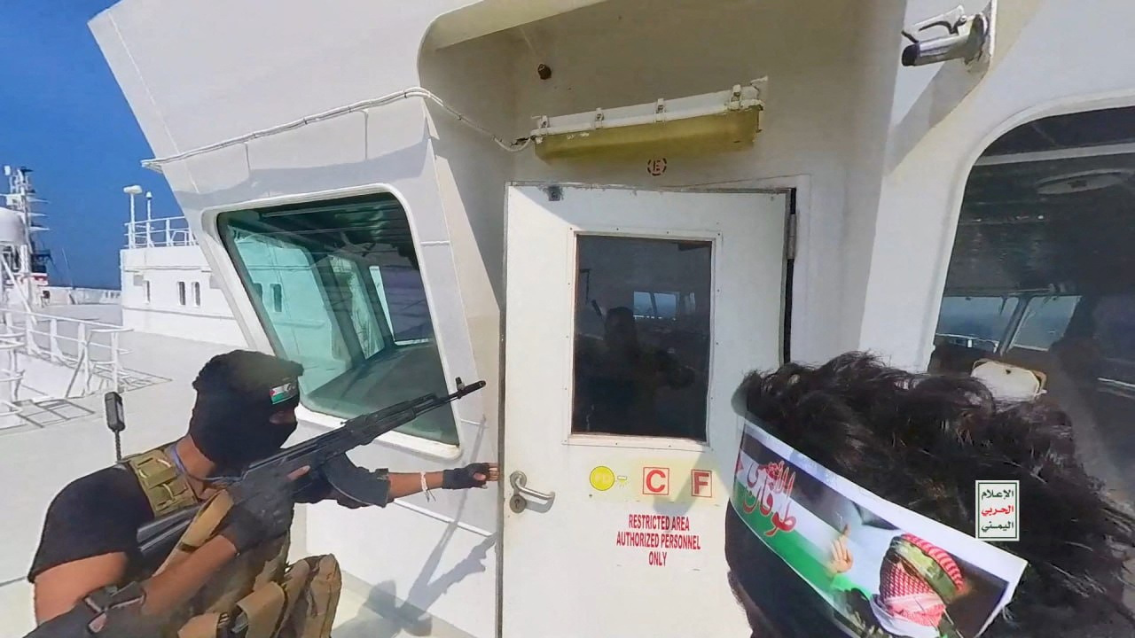Houthi fighters open the door of the cockpit on the ship's deck in the Red Sea in this photo released November 20, 2023. 