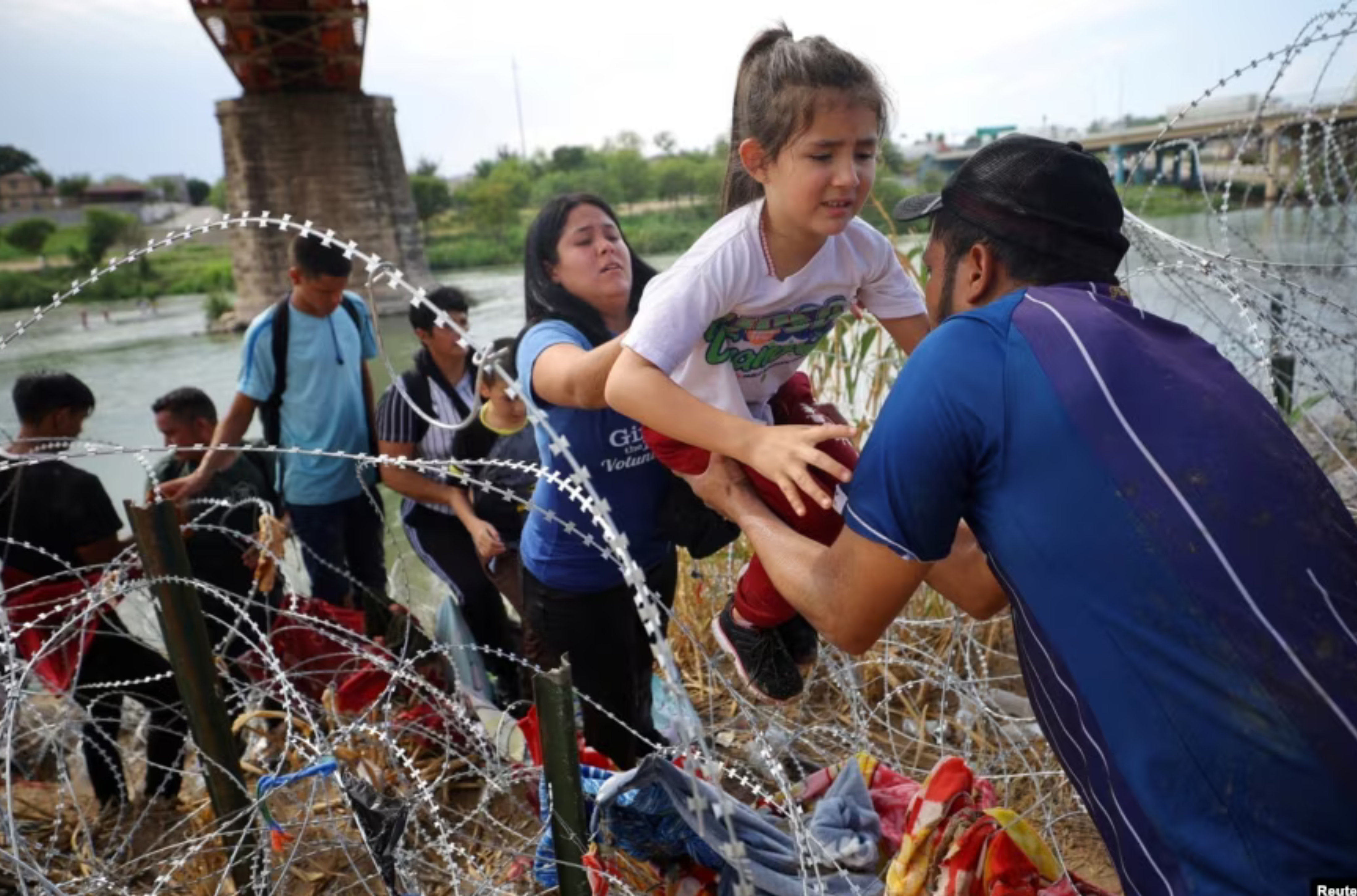 Migrants from Venezuela make their way through the razor wire after crossing the Rio Grande into the United States in Eagle Pass, Texas, Sept. 26, 2023. REUTERS