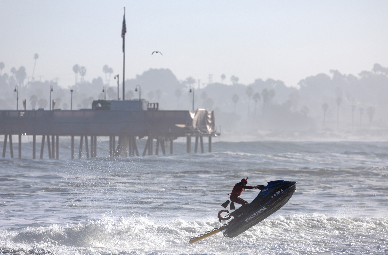 A Harbor Patrol lifeguard jumps a wave near Ventura Pier on Thursday, Dec. 28, 2023, in Ventura, California. (Brian van der Brug/Los Angeles Times/TNS)