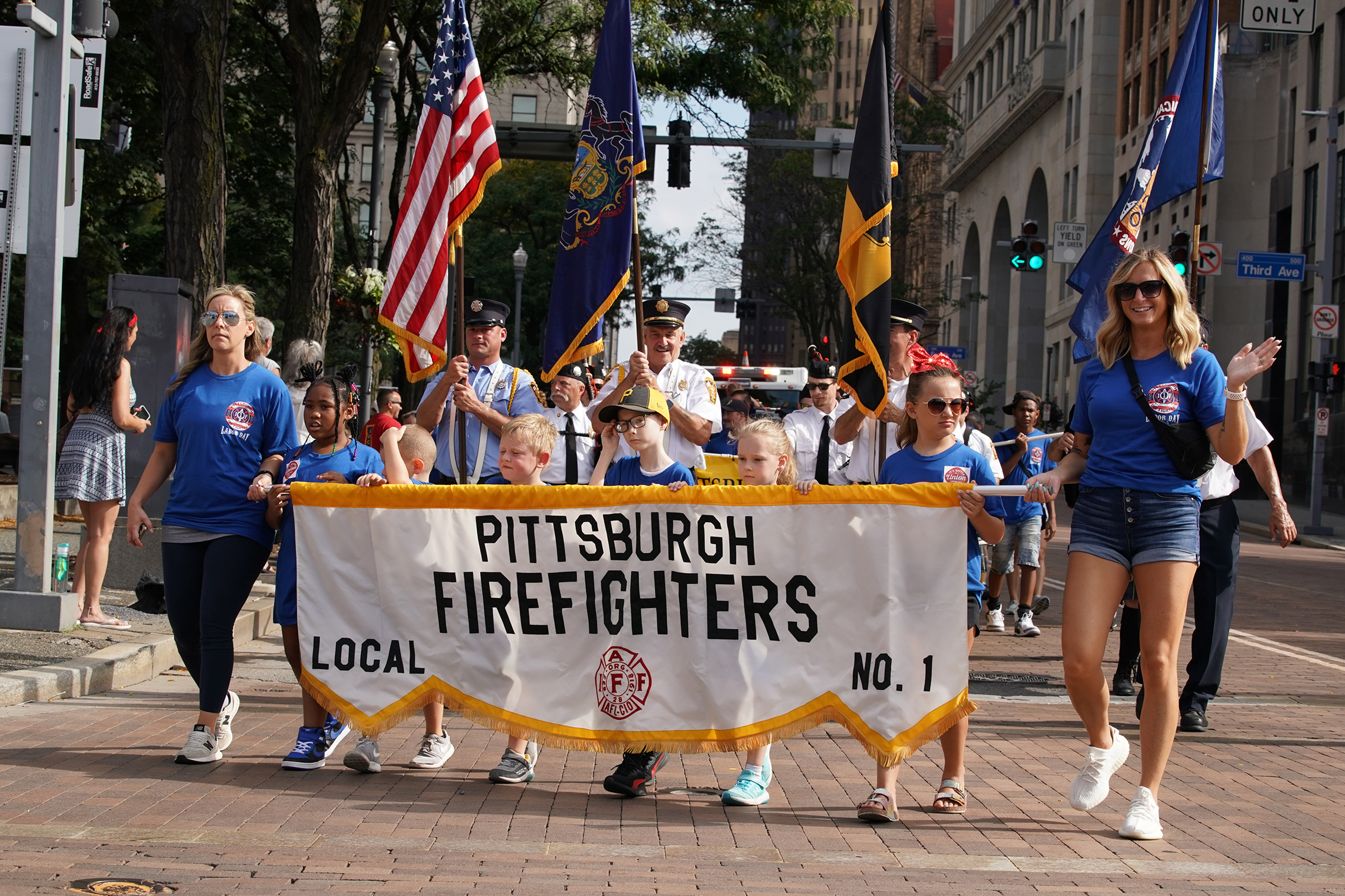 Children of Pittsburgh Firefighters carry the firefighters union banner down Grant Street in Pittsburghâ€™s Labor Day Parade Monday, Sept. 4, 2023. (Sebastian Foltz/Pittsburgh Post-Gazette/TNS)