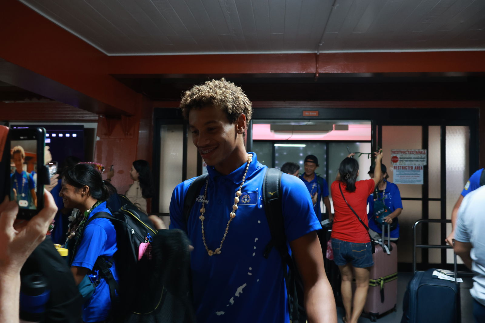 NMI swimmer Isaiah Aleksenko is all smiles as he and his fellow swimmers are greeted by family members at the Francisco C. Ada/Saipan International Airport on Sunday night.