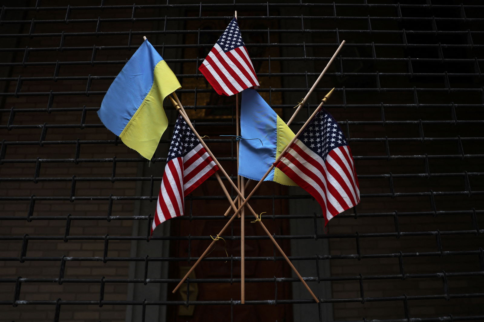 The flags of the United States and Ukraine hang on the fence of the Saint George Ukrainian Catholic Church in New York City, U.S., March 6, 2023. 