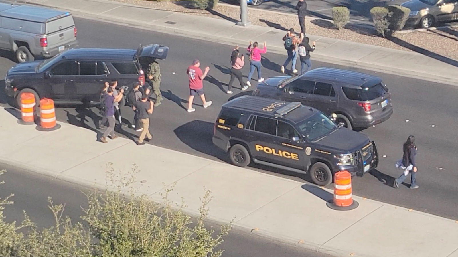 People leave campus with raised hands following reports of a shooting at the University of Nevada, in the campus of Las Vegas, U.S., December 6, 2023, in this screen grab taken from a handout video. 