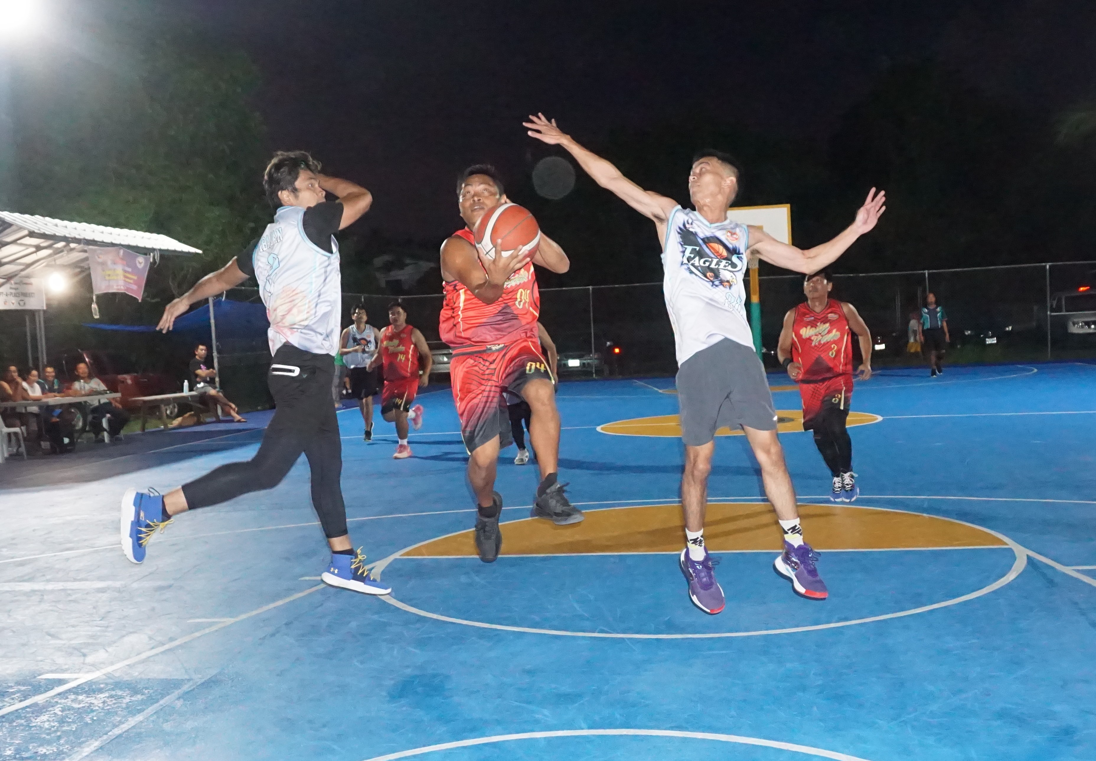 Unity Trade's Vinz Rodriguez extends for the finish between two defenders during a game of the Pacific Saipan Promo Invitational Basketball League 2023 at the Gualo Rai basketball court.