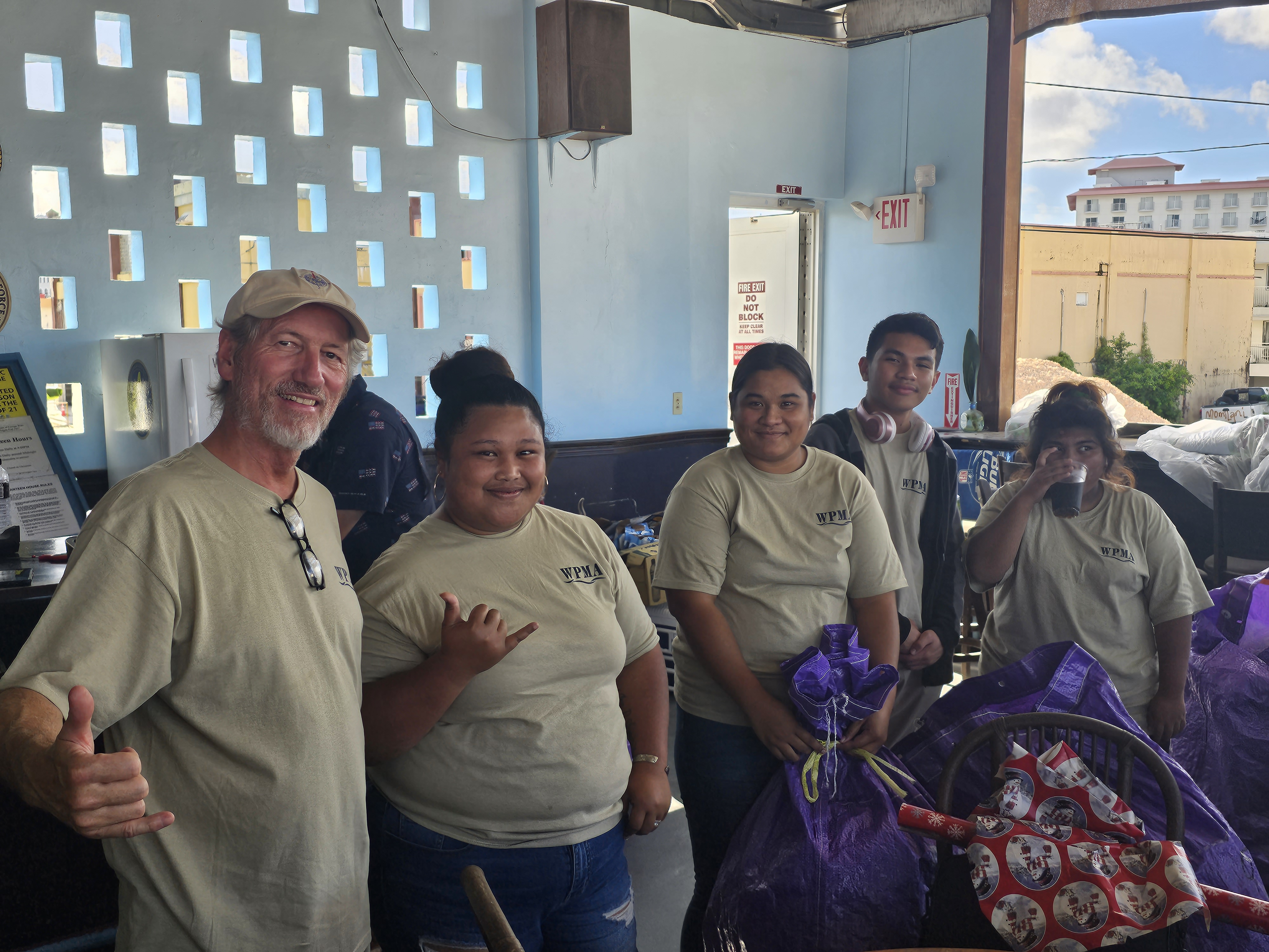 Ambyth Shipping and the Western Pacific Maritime Academy assisted with the charitable efforts. Here, Captain Michael Bacher and WPMA cadets are photographed after wrapping presents for Guma Esperanza