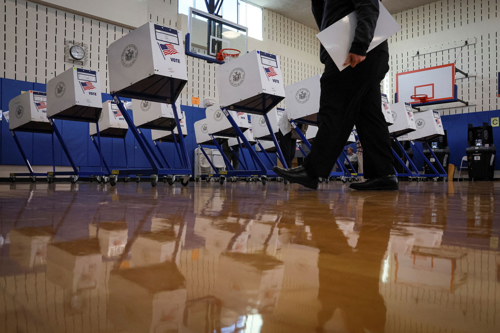 A voter walks with a ballot at a polling station during voting for the 2022 midterm elections in Brooklyn, New York, U.S., November 8, 2022. 