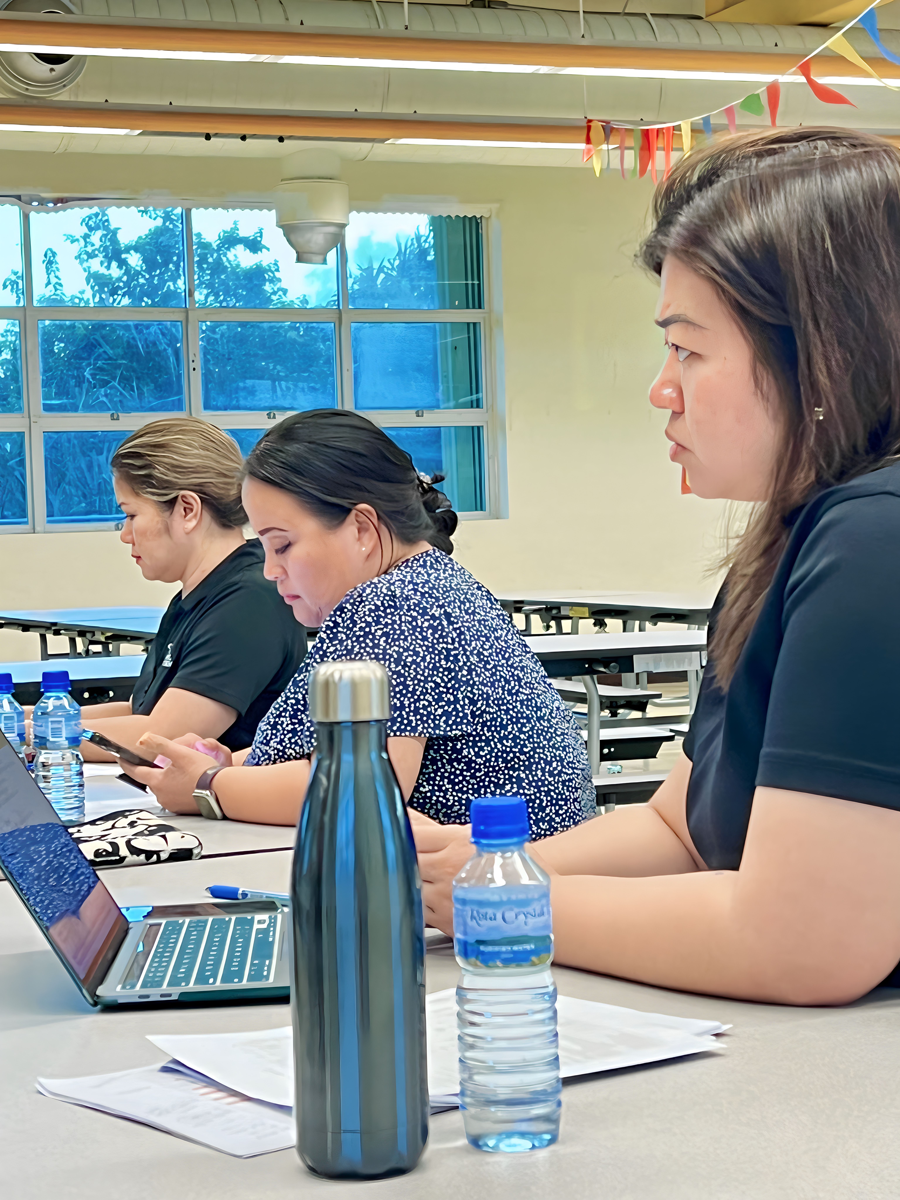 Federal Programs Officer Jacqueline Che, Human Resources Officer Lucretia Deleon Guerrero and Finance and Budget Director Arlene Lizama listen during the Board of Education meeting in the cafeteria of Sinapalo Elementary School on Rota, Monday.