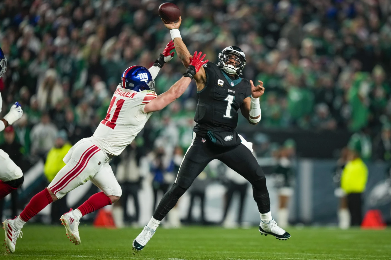 Philadelphia Eagles quarterback Jalen Hurts passes under pressure by New York Giants linebacker Micah McFadden during the first half of an NFL game Monday, Dec. 25, 2023 in Philadelphia.
