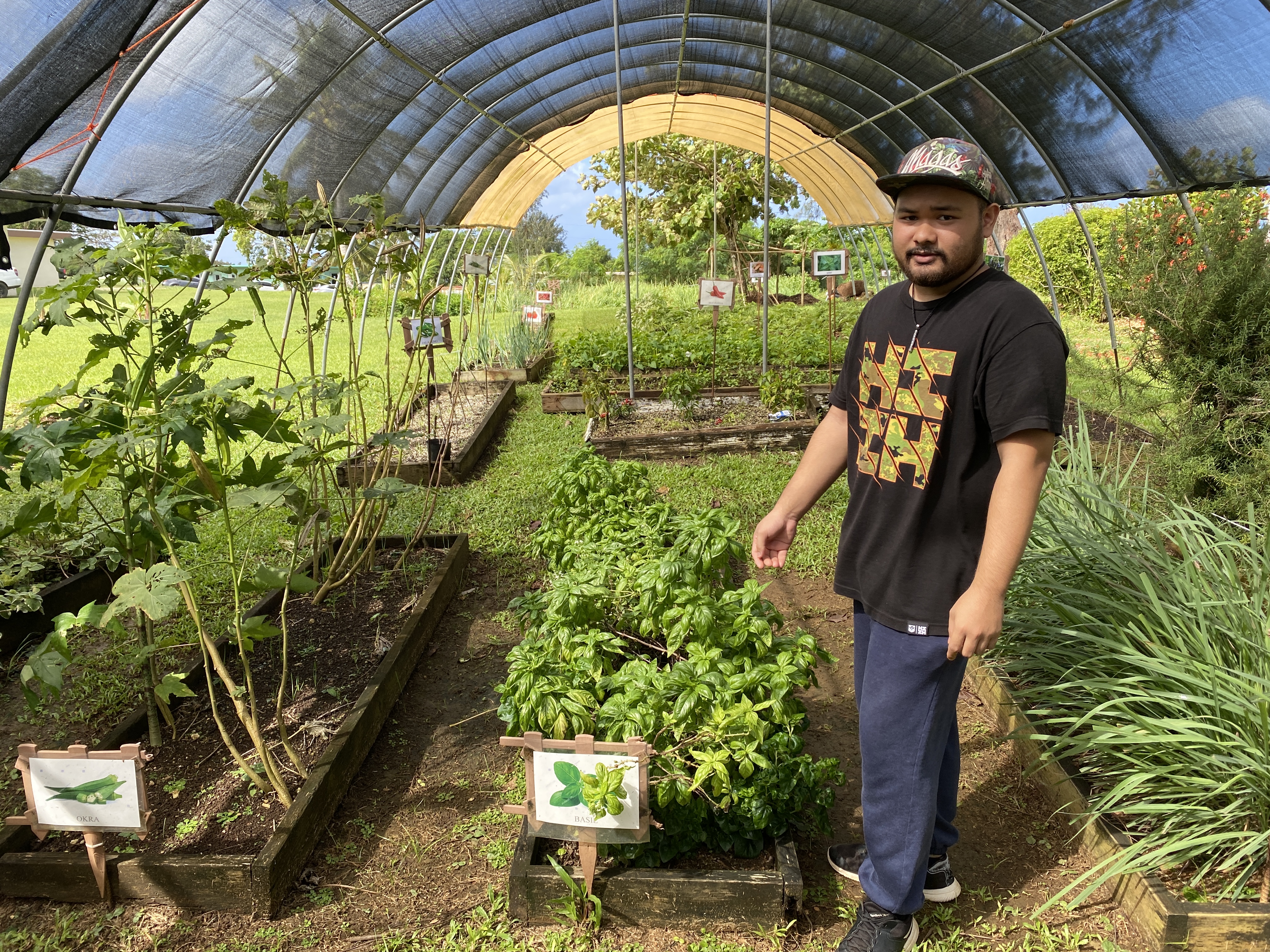 Ignacio Leon Guerrero, a NMTECH graduate and chef, shows the media what plants grow in the in-ground garden at the Center for Living Independently.
