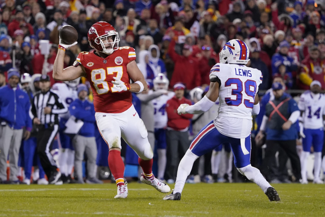 Kansas City Chiefs tight end Travis Kelce (87) laterals to teammate Kadarius Toney, not seen, as Buffalo Bills cornerback Cam Lewis (39) defends during the second half of an NFL game Sunday, Dec. 10, 2023 in Kansas City, Mo.