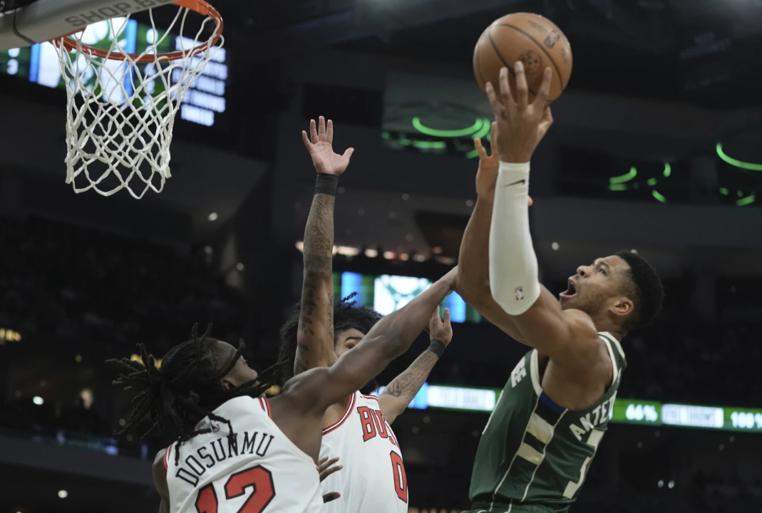 Milwaukee Bucks’ Giannis Antetokounmpo shoots over Chicago Bulls’ Ayo Dosunmu and Coby White during the first half of an NBA game Monday, Dec. 11, 2023, in Milwaukee.