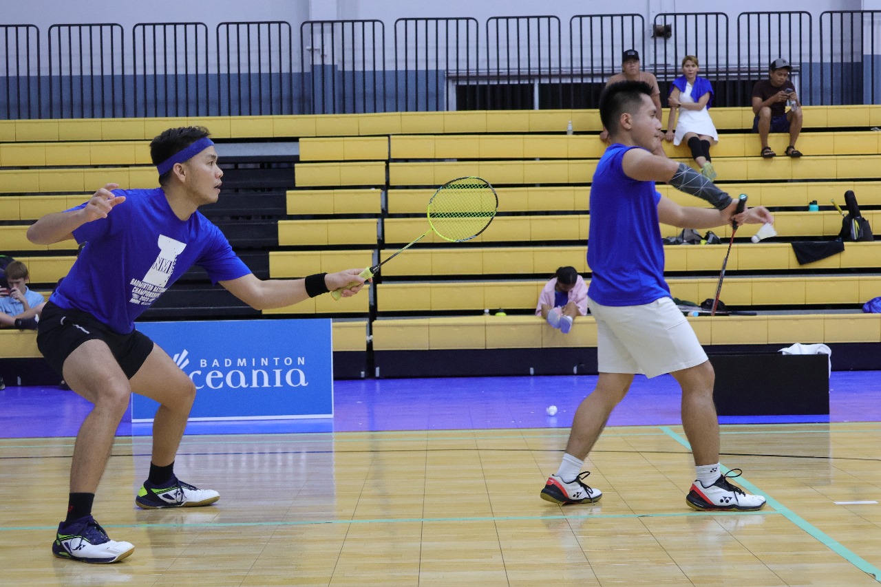 Lance Gallardo preps for the return as teammate Andreau Galvez serves during a Men's Doubles match of the NMI Badminton National Championships at the Ada gym.