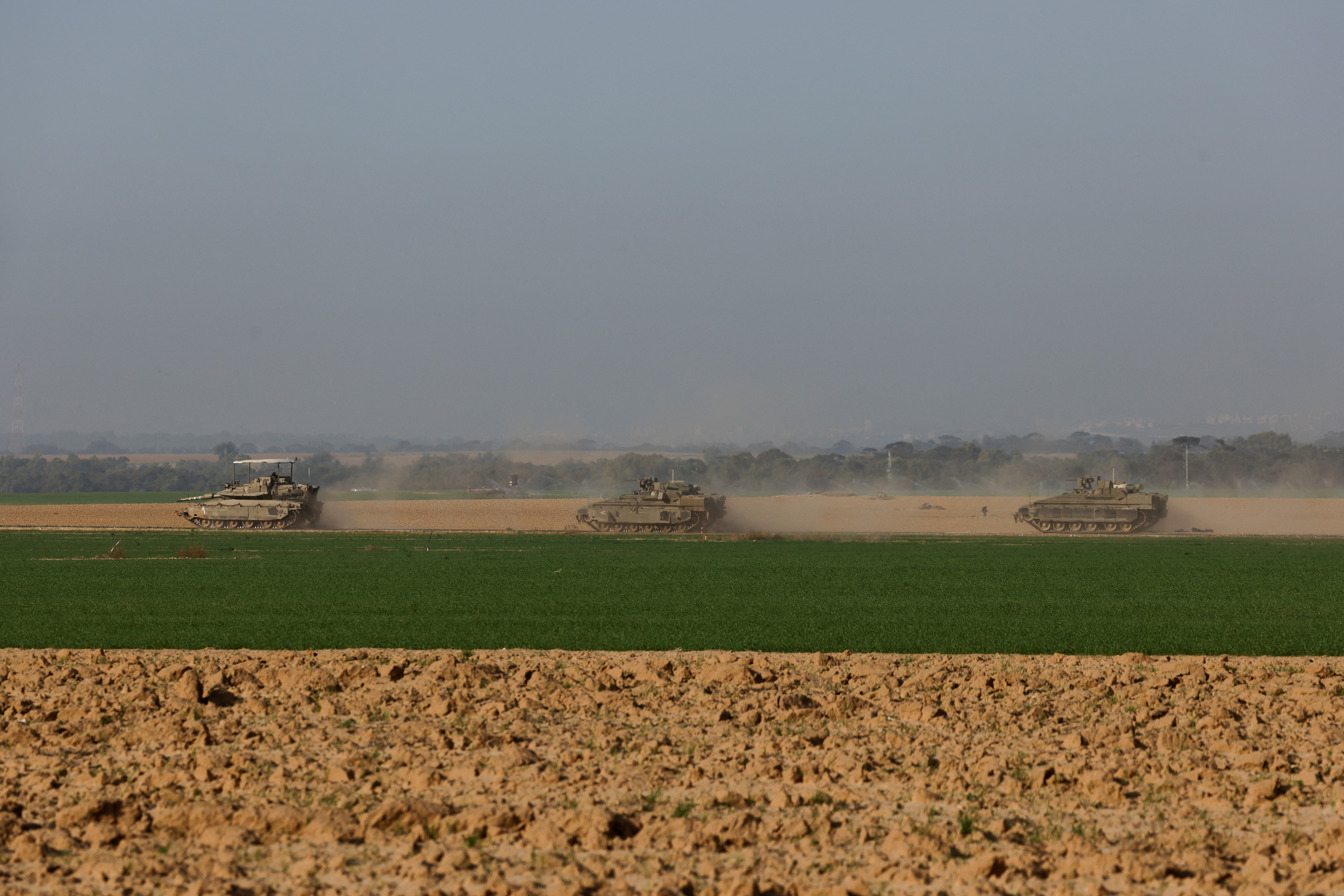 An Israeli tank and armored personnel carriers (APC) maneuver near Israel's border with southern Gaza, amid the ongoing conflict between Israel and the Palestinian Islamist group Hamas, in Israel, December 4, 2023. 