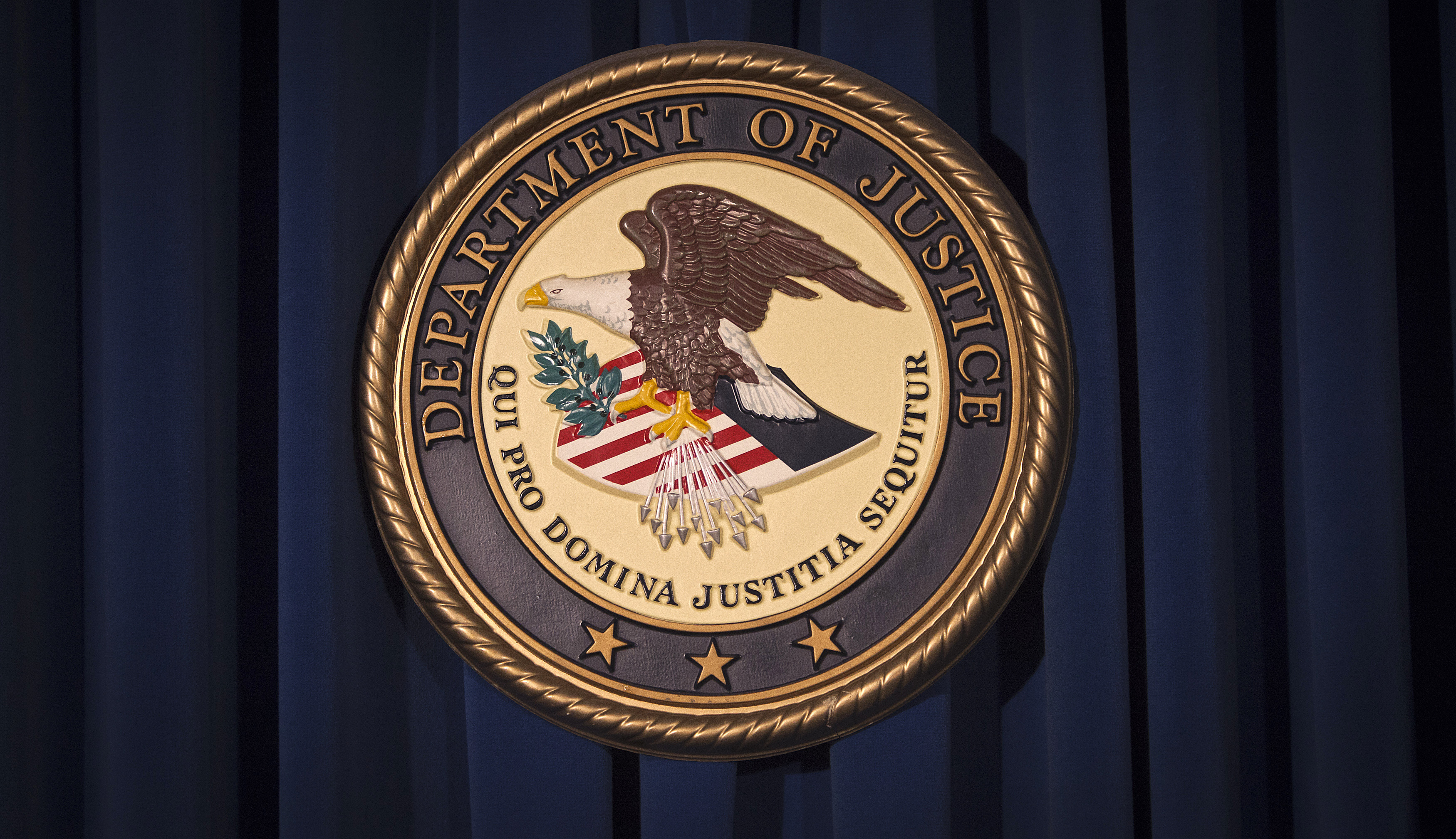 The Department of Justice (DOJ) logo is pictured on a wall after a news conference in New York December 5, 2013. 