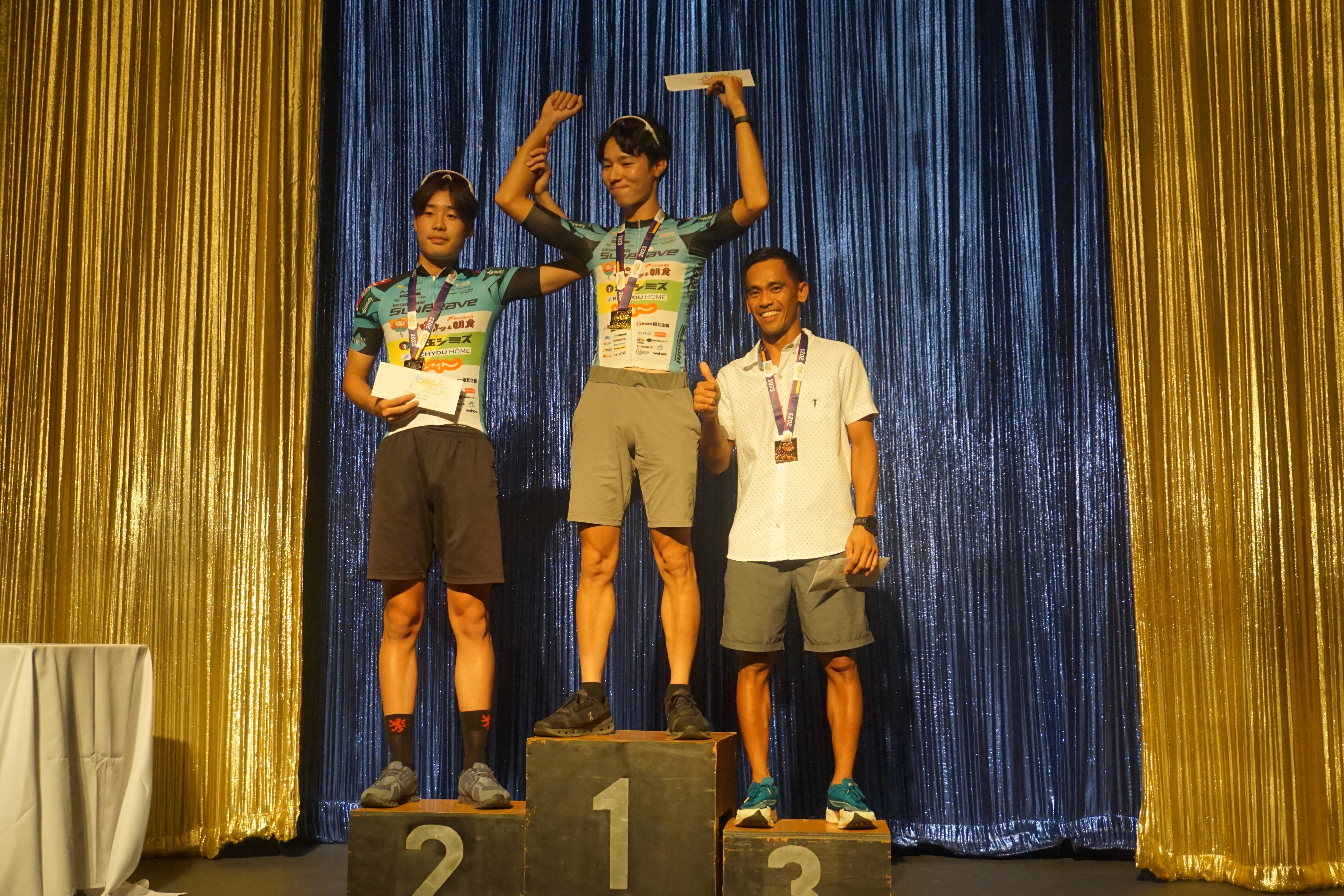 Japan's Ryohei Fujita, center, and Rinichiro Shigeta, left, pose with Guam’s Ryan Matienzo during an awards ceremony Saturday at the Hyatt Regency Ballroom. They were the top three cyclists in the pro/elite men's division of the 2023 Hell of the Marianas