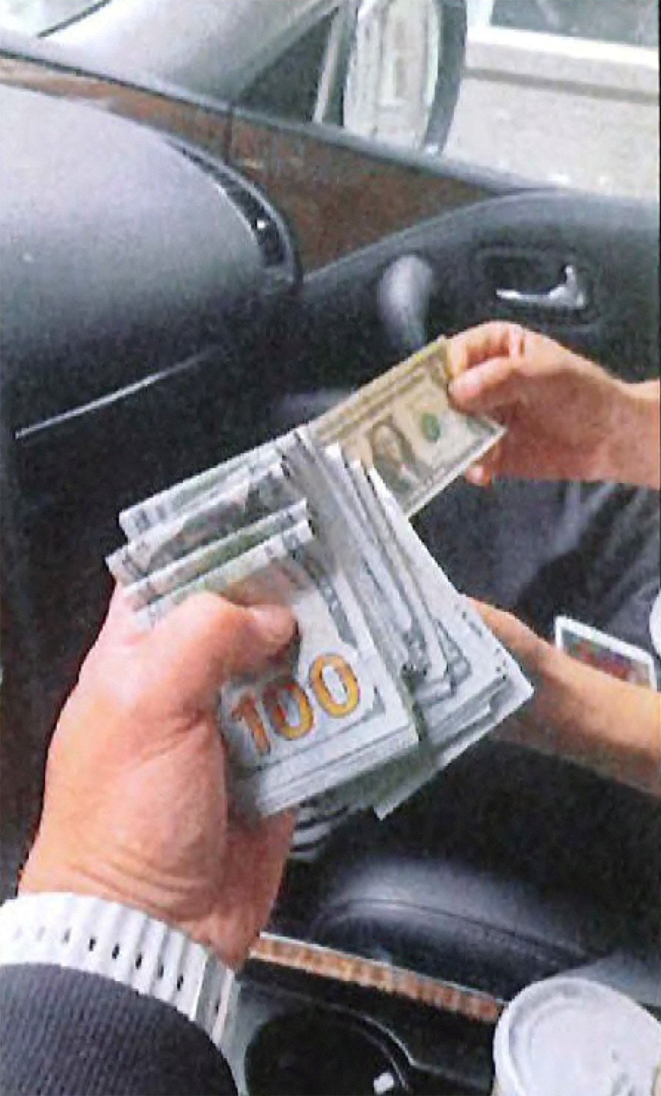 An undercover U.S. law enforcement officer is handed $15,000, described by the U.S. Department of Justice as the advance cash payment, by an associate of Nikhil Gupta, who was charged with orchestrating the attempted murder of a Sikh separtist, in a car in the Manhattan borough of New York City, U.S. June 9, 2023, in a photograph contained in an indictment. 