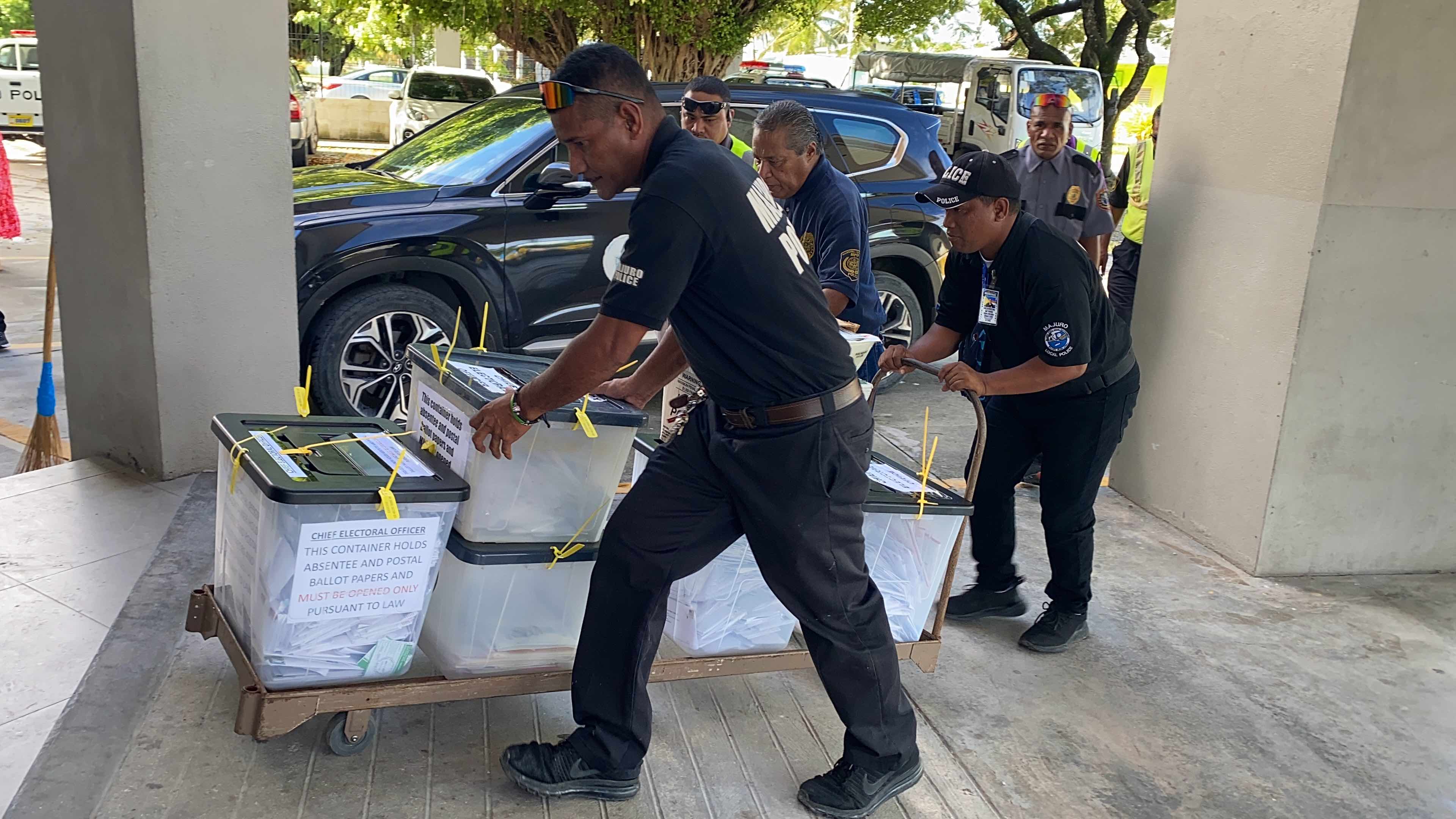 Police officers transport boxes containing postal absentee ballots from the main post office in Majuro to the election tabulation headquarters on December 4. Barely 40 percent of the absentee ballots mailed to offshore voters were returned in time to be tabulated.