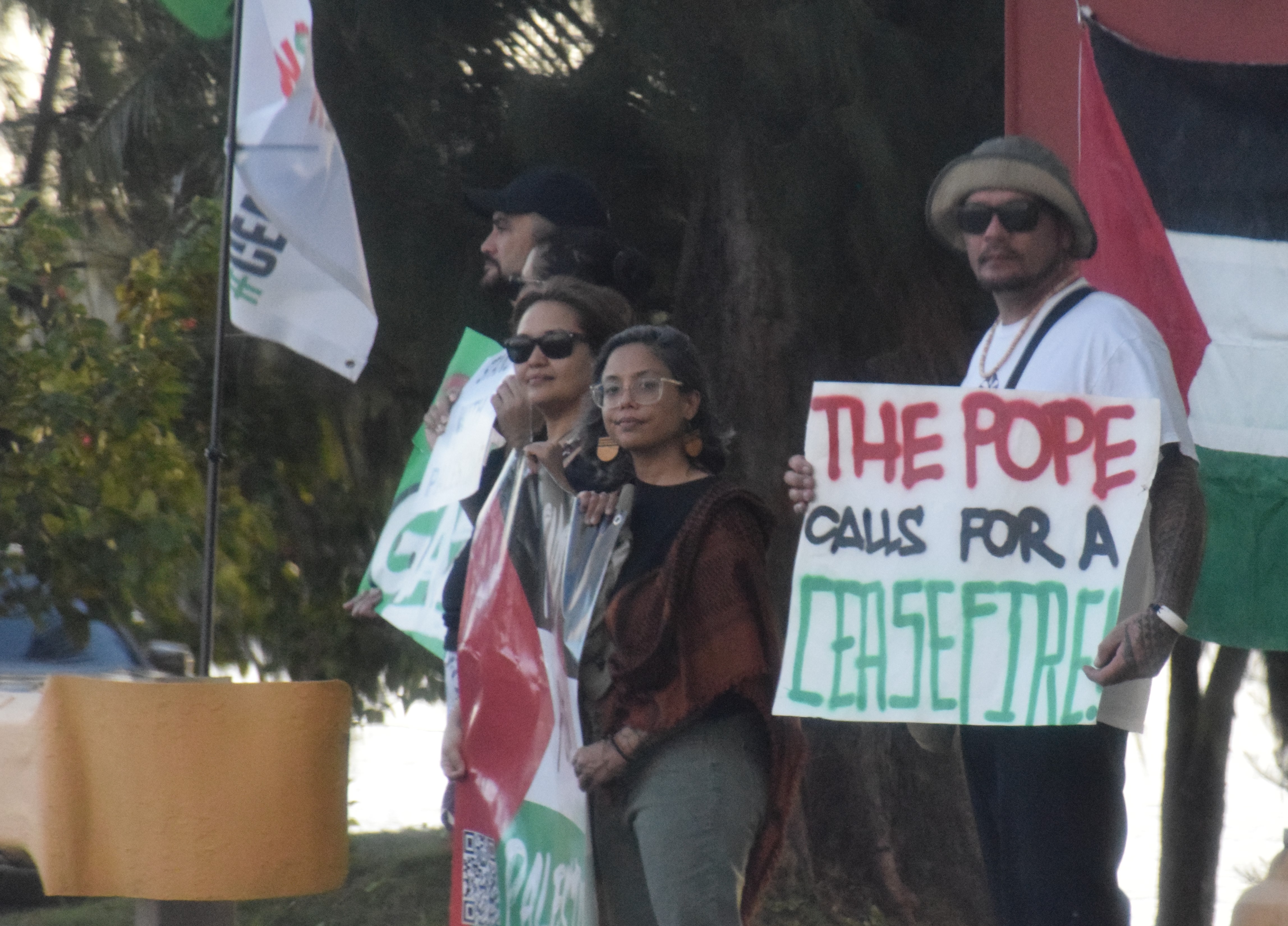Monica Flores, center, and Salam Younis, left, and other concerned citizens hold a protest action calling for a ceasefire in Palestine at the San Jose intersection on Tuesday.