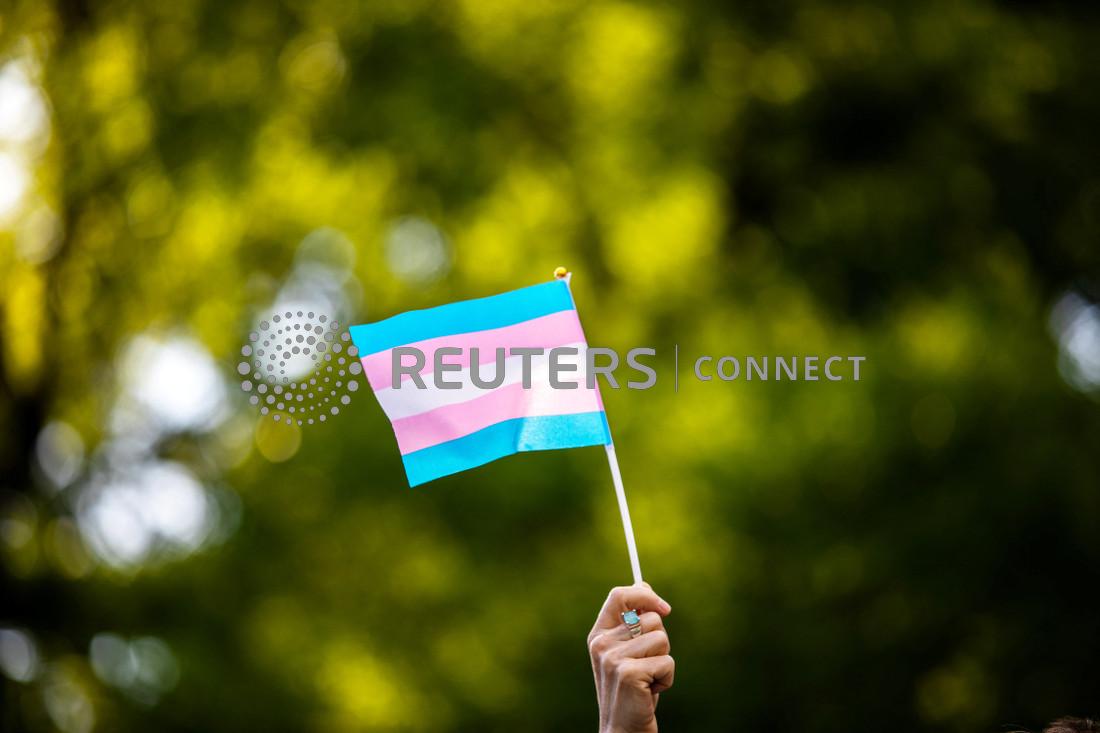 Transgender rights activist waves a transgender flag as they protest the killings of transgender women this year, at a rally in Washington Square Park in New York, U.S., May 24, 2019. 