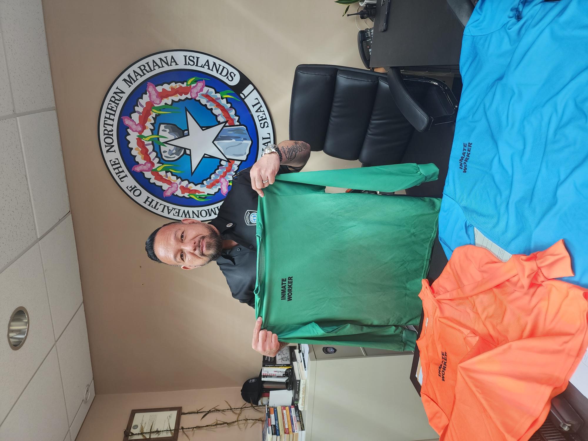 Corrections Commissioner Anthony Torres holds a uniform to be worn by inmates during voluntary public work.