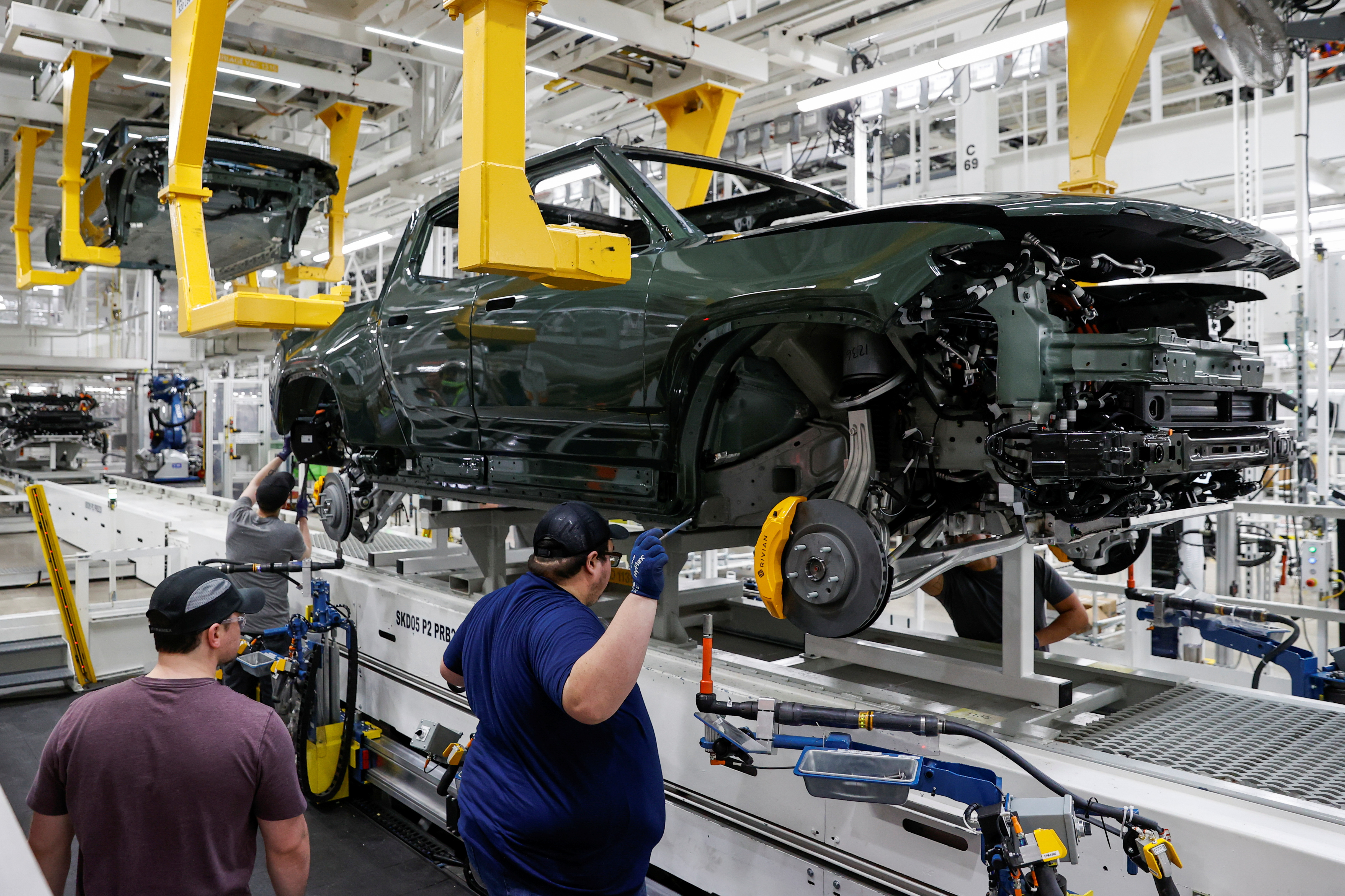 Employees works on an assembly line at startup Rivian Automotive's electric vehicle factory in Normal, Illinois, U.S. April 11, 2022. Picture taken April 11, 2022. 