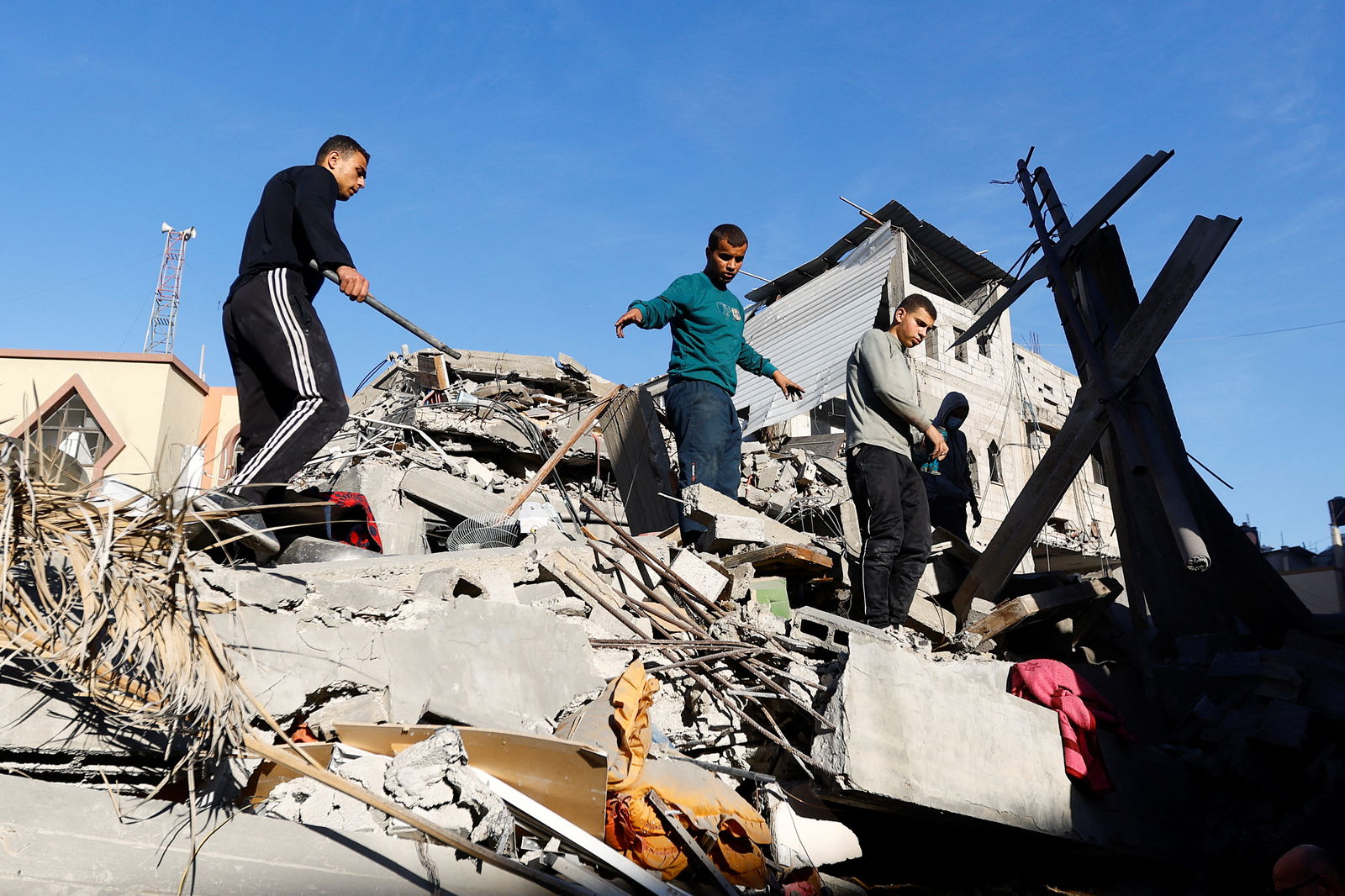 Palestinians inspect the damage at the site of Israeli strikes on houses, amid the ongoing conflict between Israel and the Palestinian Islamist group Hamas, in Khan Younis in the southern Gaza Strip, December 10, 2023. 
