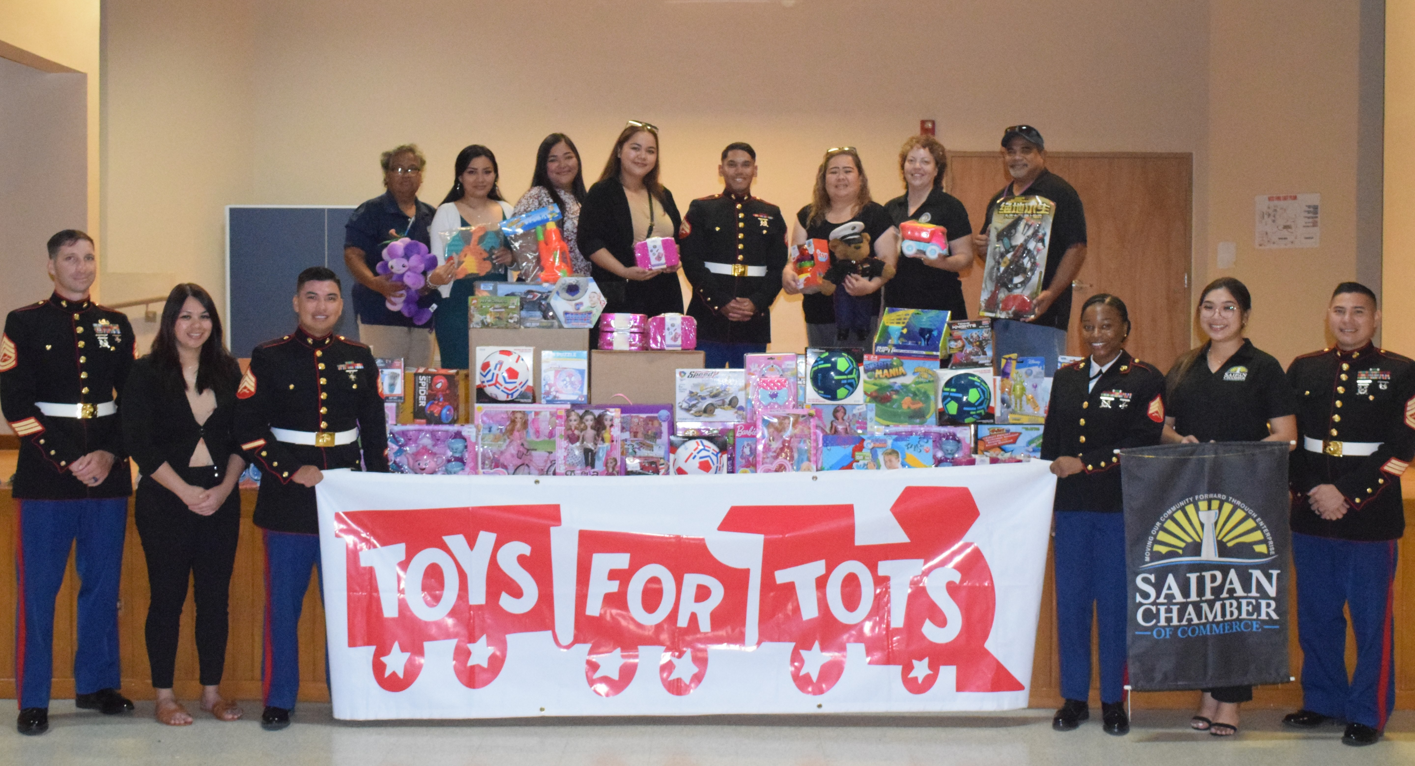 Acting Department of Community and Cultural Affairs Secretary Vivian Sablan, third right, back row, poses with other DYS personnel, Saipan Chamber of Commerce staff and members of the U.S. Marine Corps led by Toys for Tots coordinator Gunnery Sgt. Reuben James Tan at the Kagman Community Center on Tuesday.