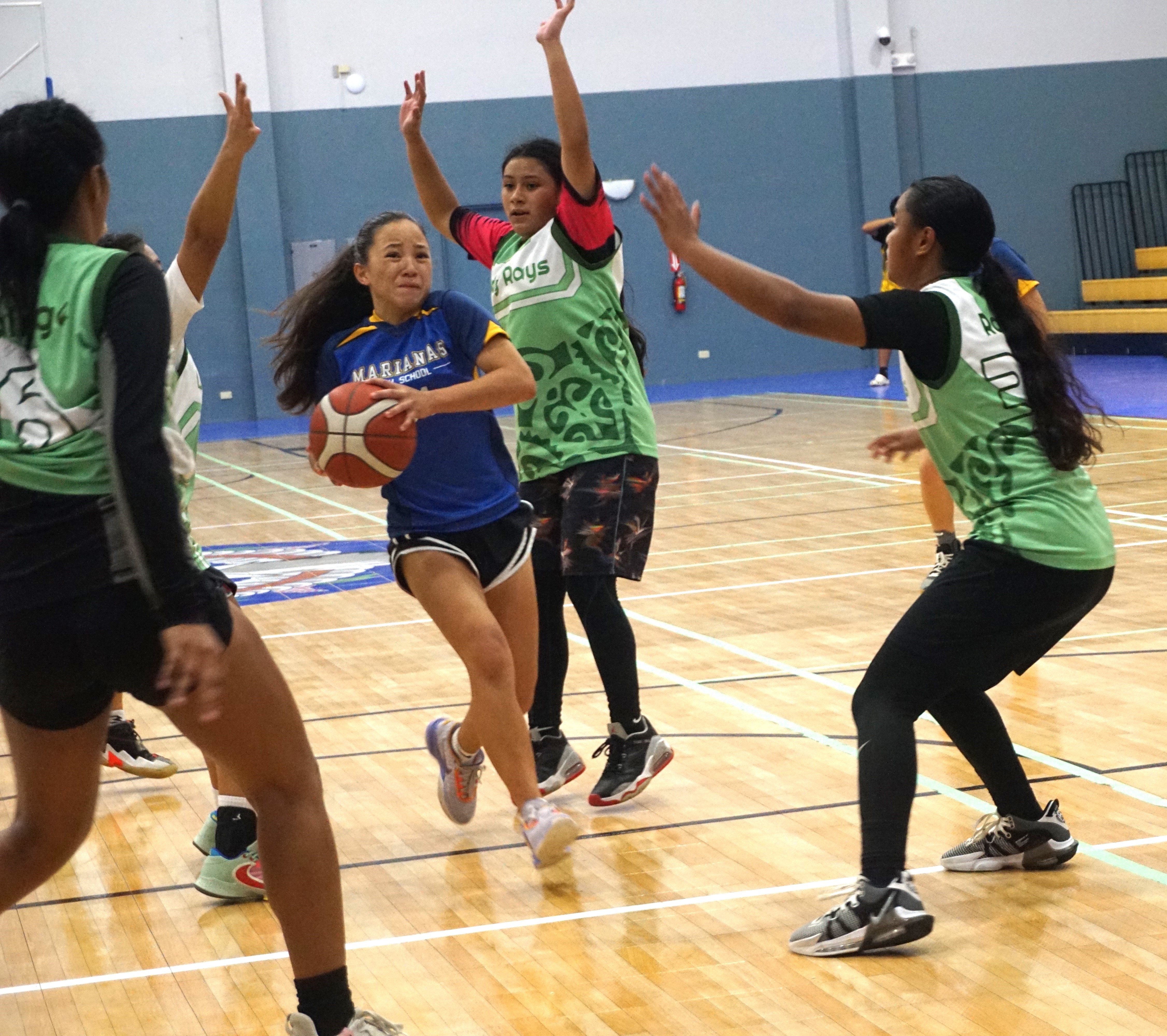 MHS' Destiny Pangelinan protects the ball as she drives in between defenders.