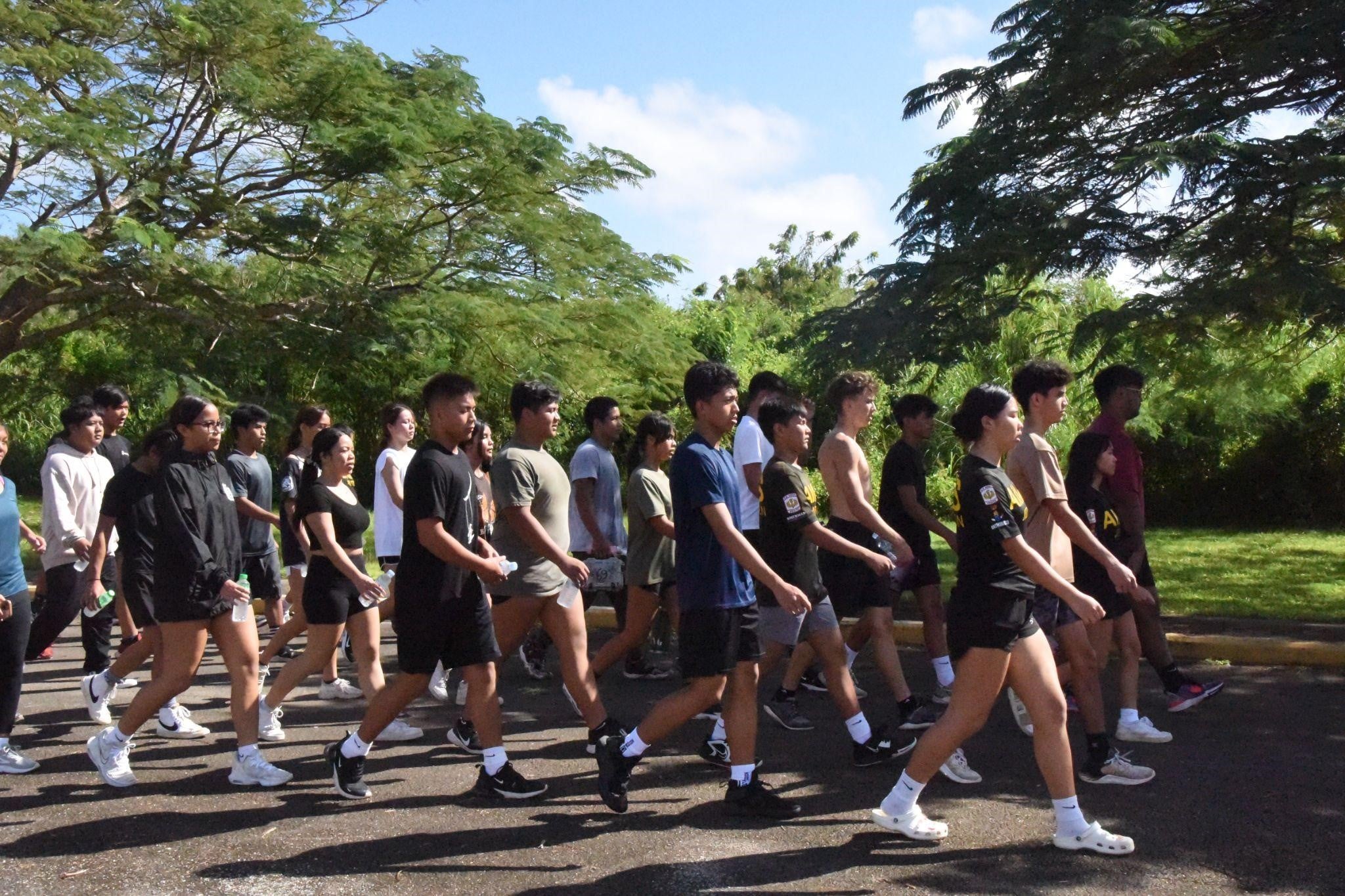 Tinian Stallion Battalion cadets marching toward the Tinian Junior-Senior High School front parking lot.