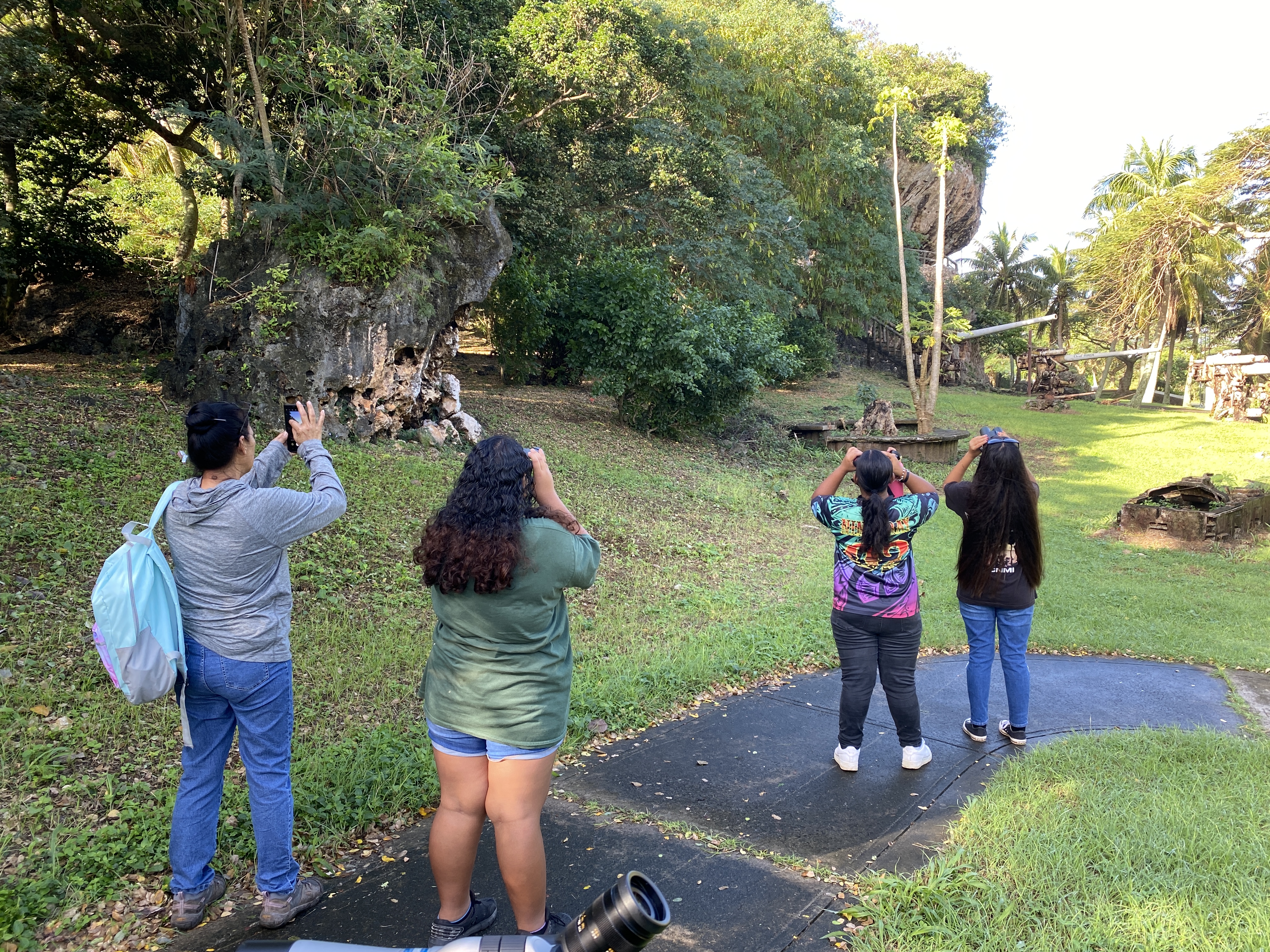 Tanapag Middle School students and their teacher, Acelia Castro, observe a collared kingfisher on a tree at Last Command Post.