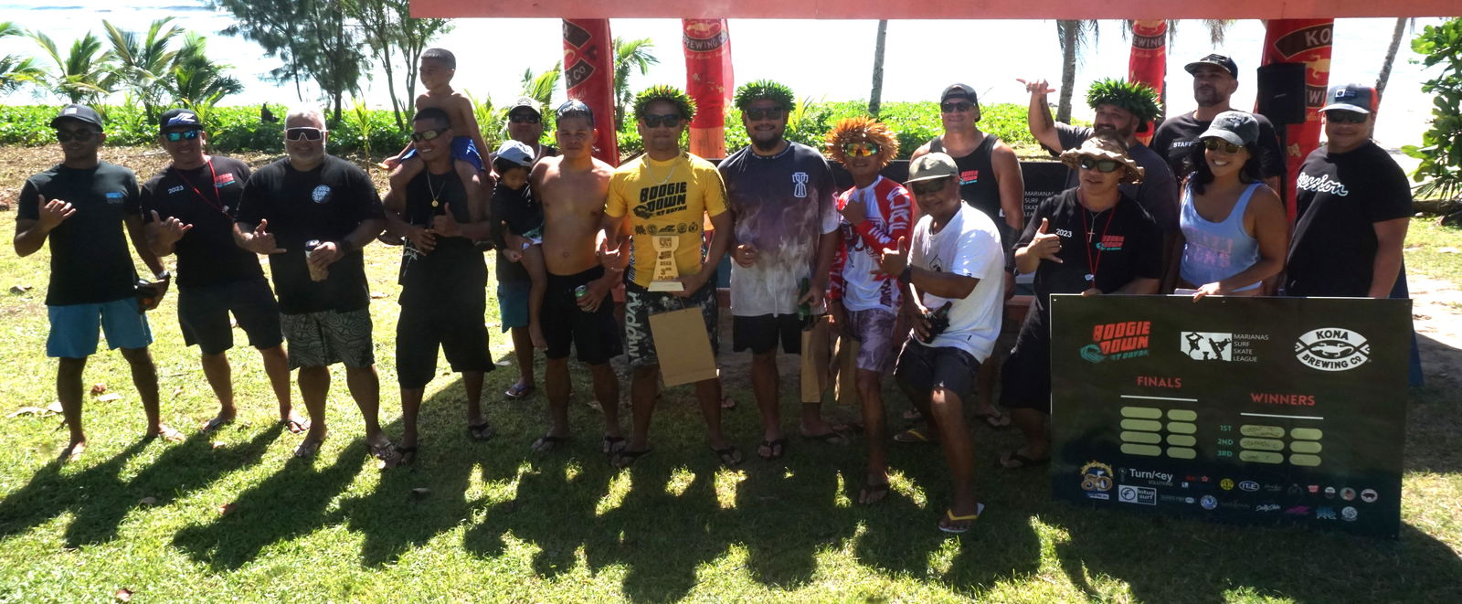 The participating 13 surfers and family members pose for a photo during  Boogie Down’s awards ceremony over the weekend at Obyan Beach.