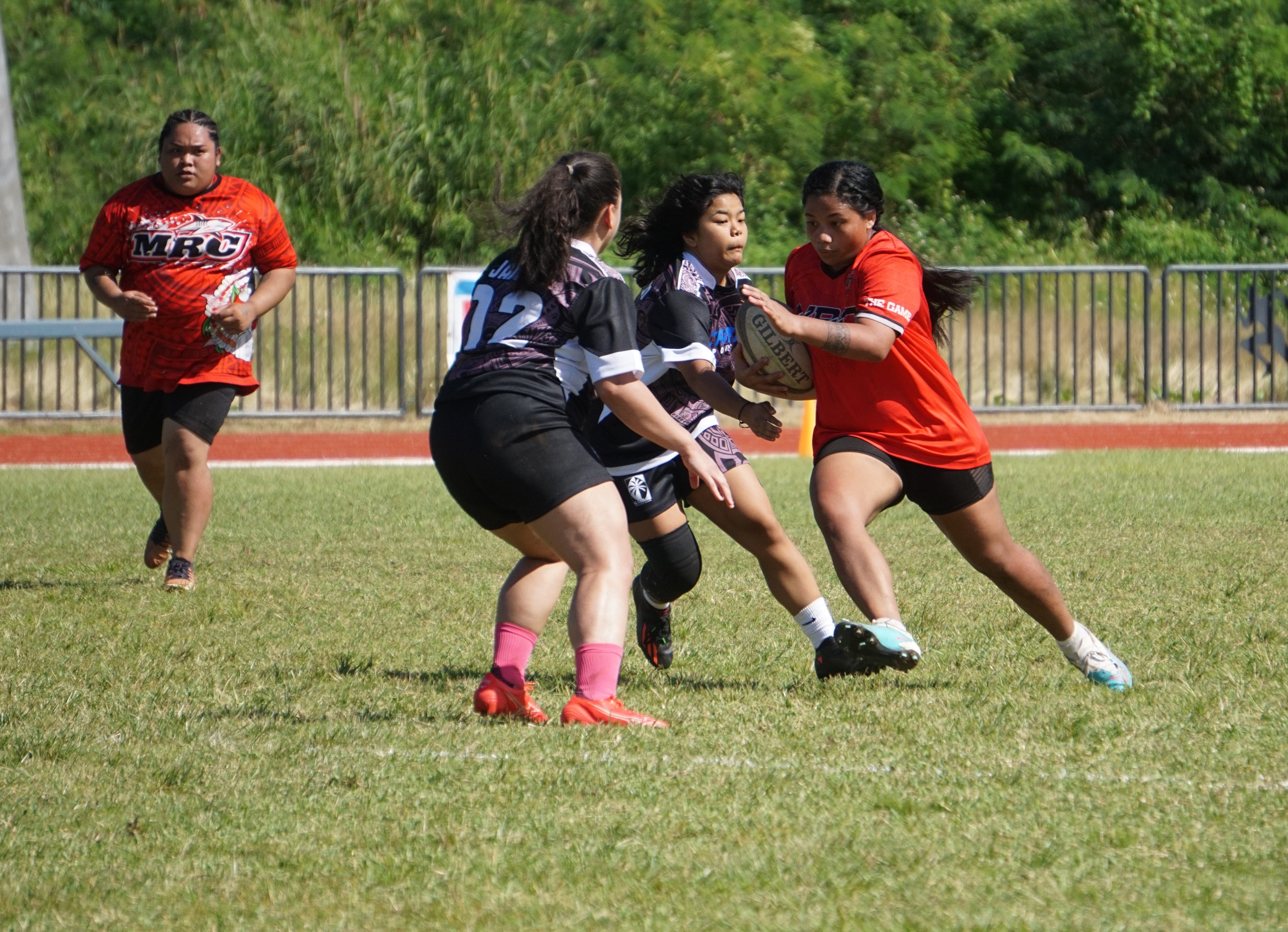 Marianas Rugby Club's team captain Tatiana Pangelinan attempts to slip between two Guam Rugby Club defenders during the first-ever Marianas Rugby Cup at the Oleai Sports Complex on Saturday.