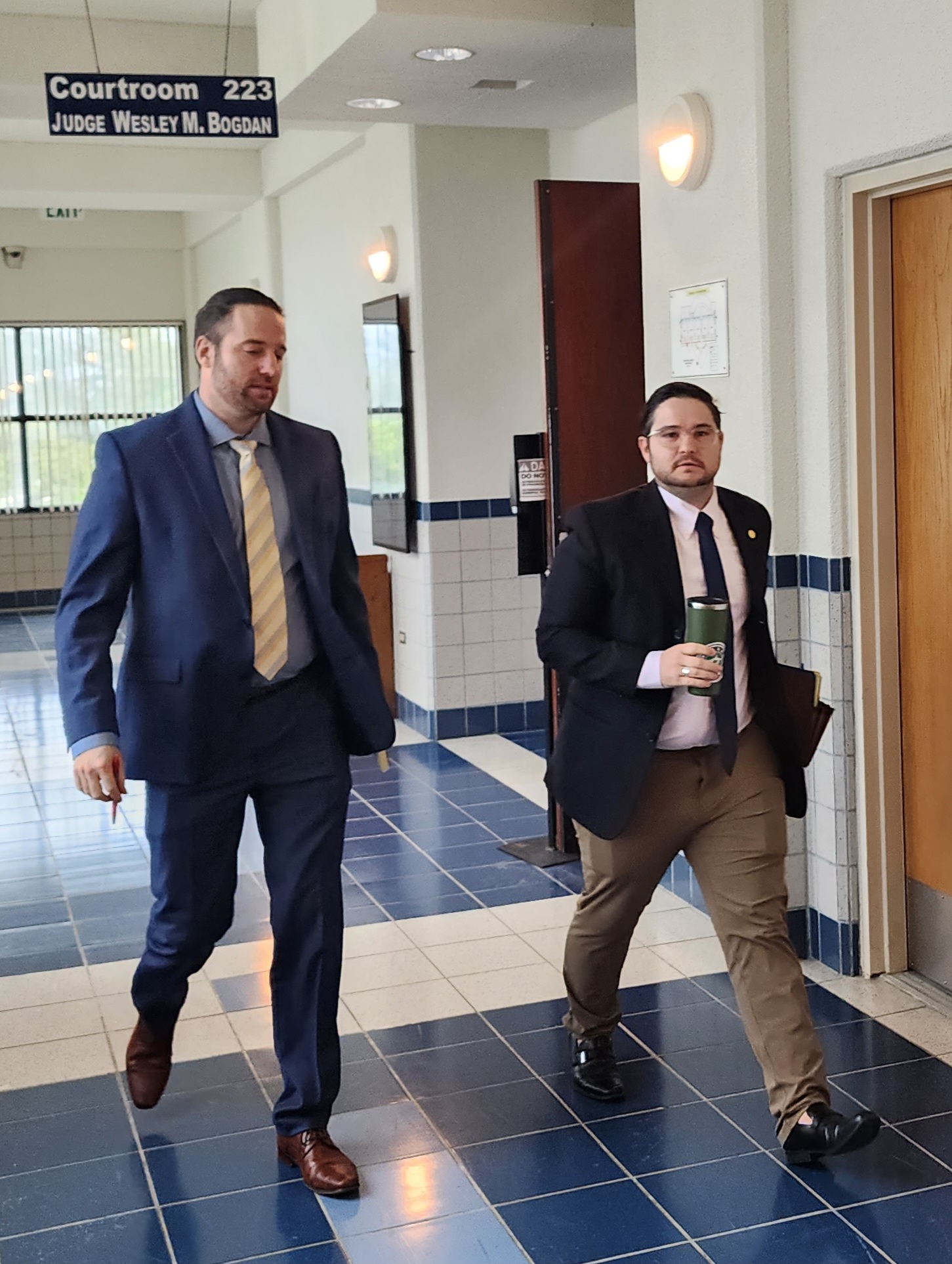 Assistant Attorney General Dustin Rollins and Chief Solicitor Robby Glass Jr. leave the courtroom after a hearing on Monday.
