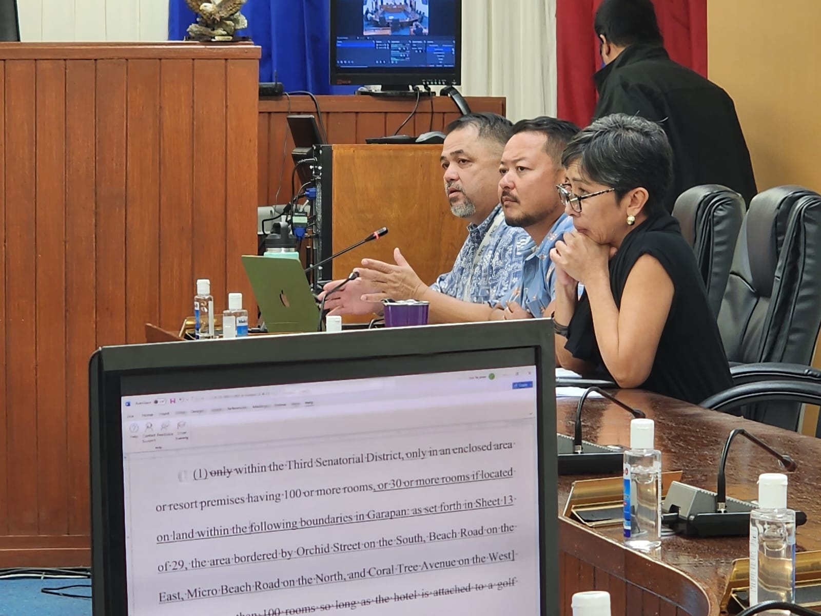 House Committee on Gaming Chairman Ralph N. Yumul, left background, talks about the proposed revision of House Bill 23-85, shown on a computer monitor, while House Vice Speaker Joel Camacho and Rep. Marissa Flores listen during a committee meeting in the House chamber on Monday.