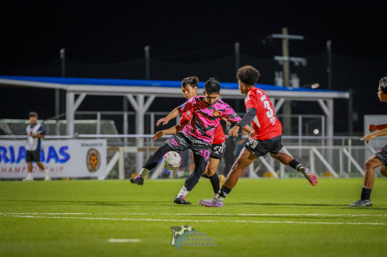 Eleven Tiger's Tanapon Unsa secures the possession as two Wings defenders close in during the Marianas Club Championship game at the NMI Soccer Training Center in Koblerville on Saturday.